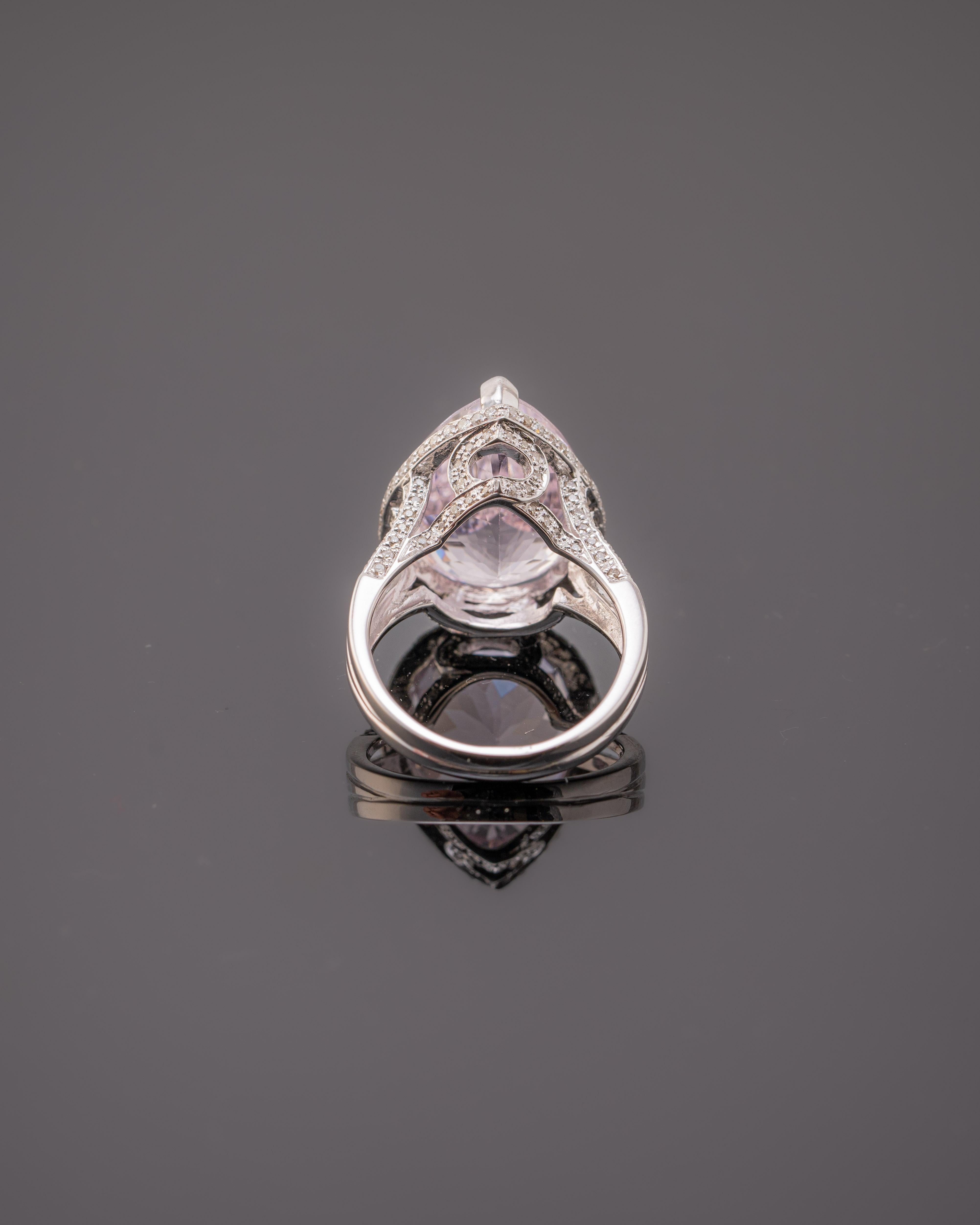 A lovely Engagement Ring Option or as an alternate to a Pink Diamond Ring! This simply stunning Kunzite Diamond Ring has a 14.6 Carat Pear Cut Kunzite as its center and has a beautiful simple halo along with two lines of Round Cut Diamonds that