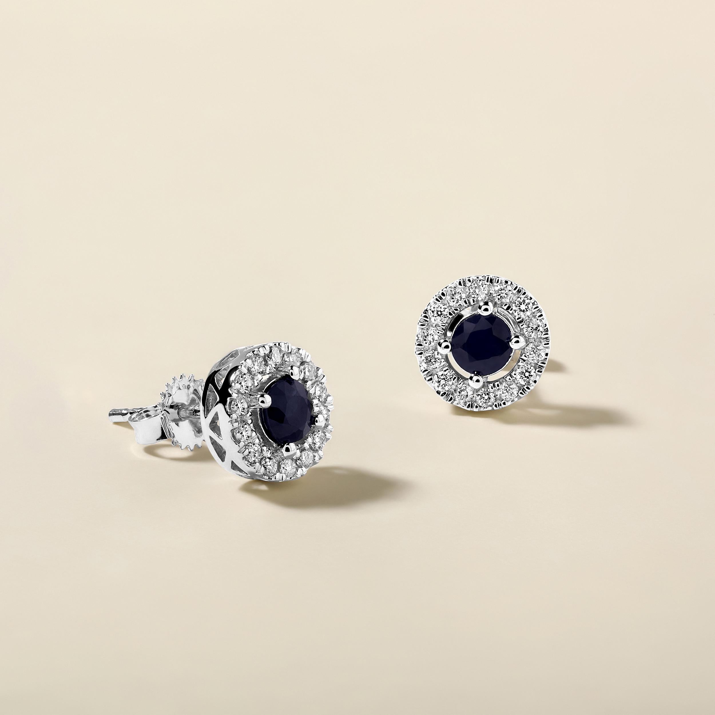 Crafted in 3.02 grams of 14K White Gold, the earrings contain 36 stones of Round Natural Diamonds with a total of 0.29 carat in F-G color and I1-I2 clarity combined with 2 stones of Round Shaped Natural Sapphire Gemstones with a total of 1.21 carat.