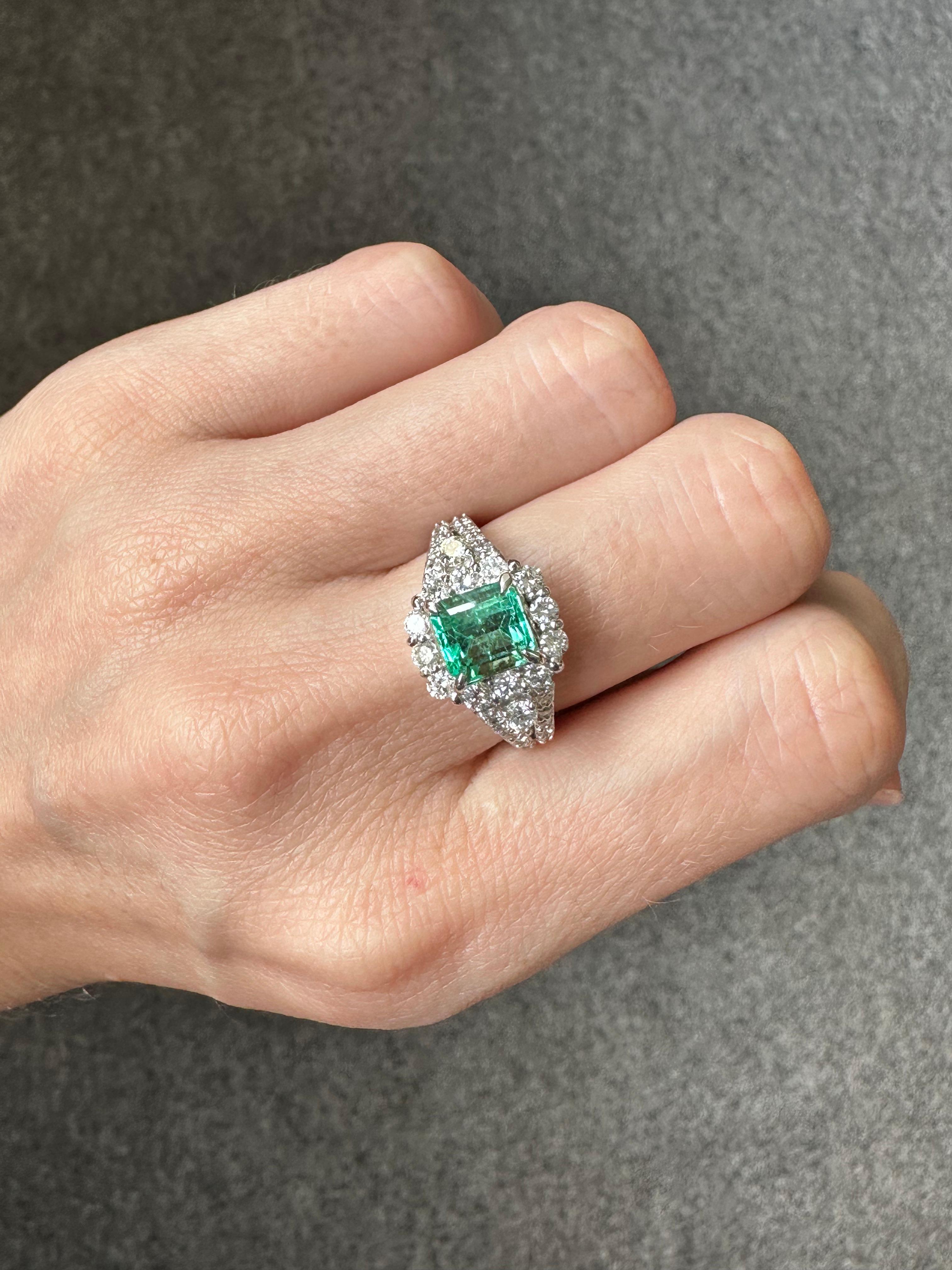 A classic 1.53 carat Colombian Emerald and 0.95 carat engagement ring in Platinum. The center stone is absolutely transparent with a beautiful aqua-teal color. The ring is sized currently at US7, can be resized. 
Please feel free to message us for