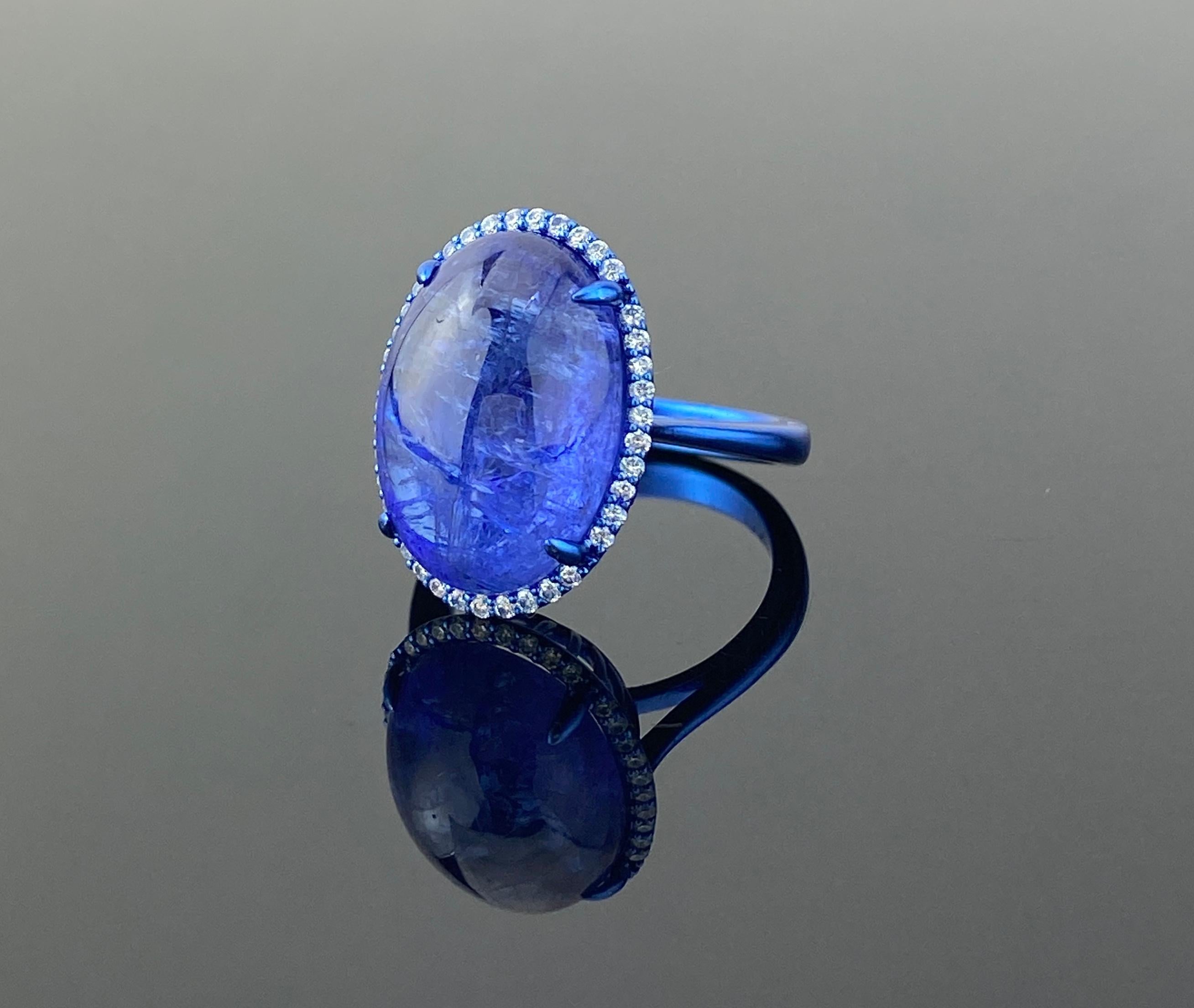 Un llamativo anillo de cóctel de cabujón de tanzanita certificado de 15,61 quilates con diamantes de calidad VS/SI de 0,30 quilates que enmarcan delicadamente la pieza central. La tanzanita natural tiene un tono impresionante y es transparente, con