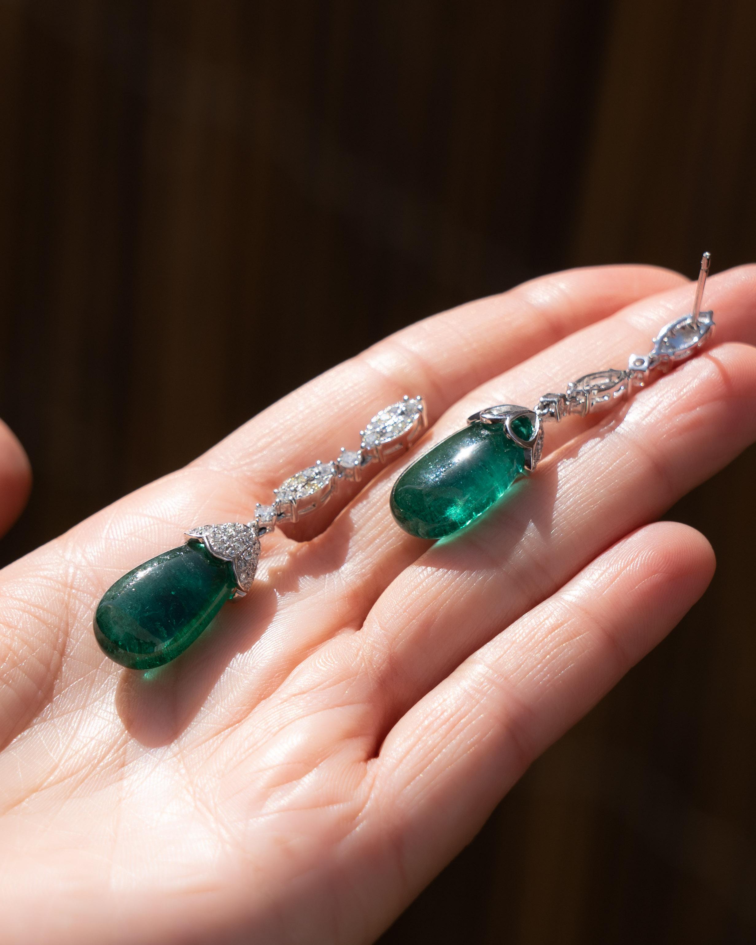 Exquisite pair of Emerald drop earrings crafted in 18 karat white gold and featuring approximately 1.21 carats of fine white diamonds ( G / VS2 ) and 29.59 carats carats of vivid green emeralds. The earrings radiate with feminine elegance and