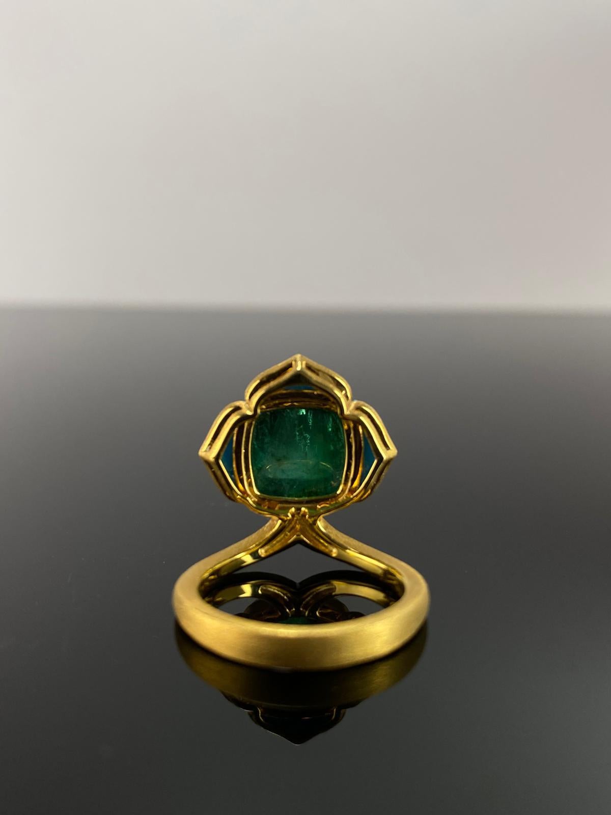 A natural cushion-cab Zambian emerald in a sugarloaf shape, weighing 9.60 carats, sits at the heart of this ring. Accentuating the emerald are three turquoise stones totaling 3.1 carats, adding a bright and refreshing contrast . 

A bold and