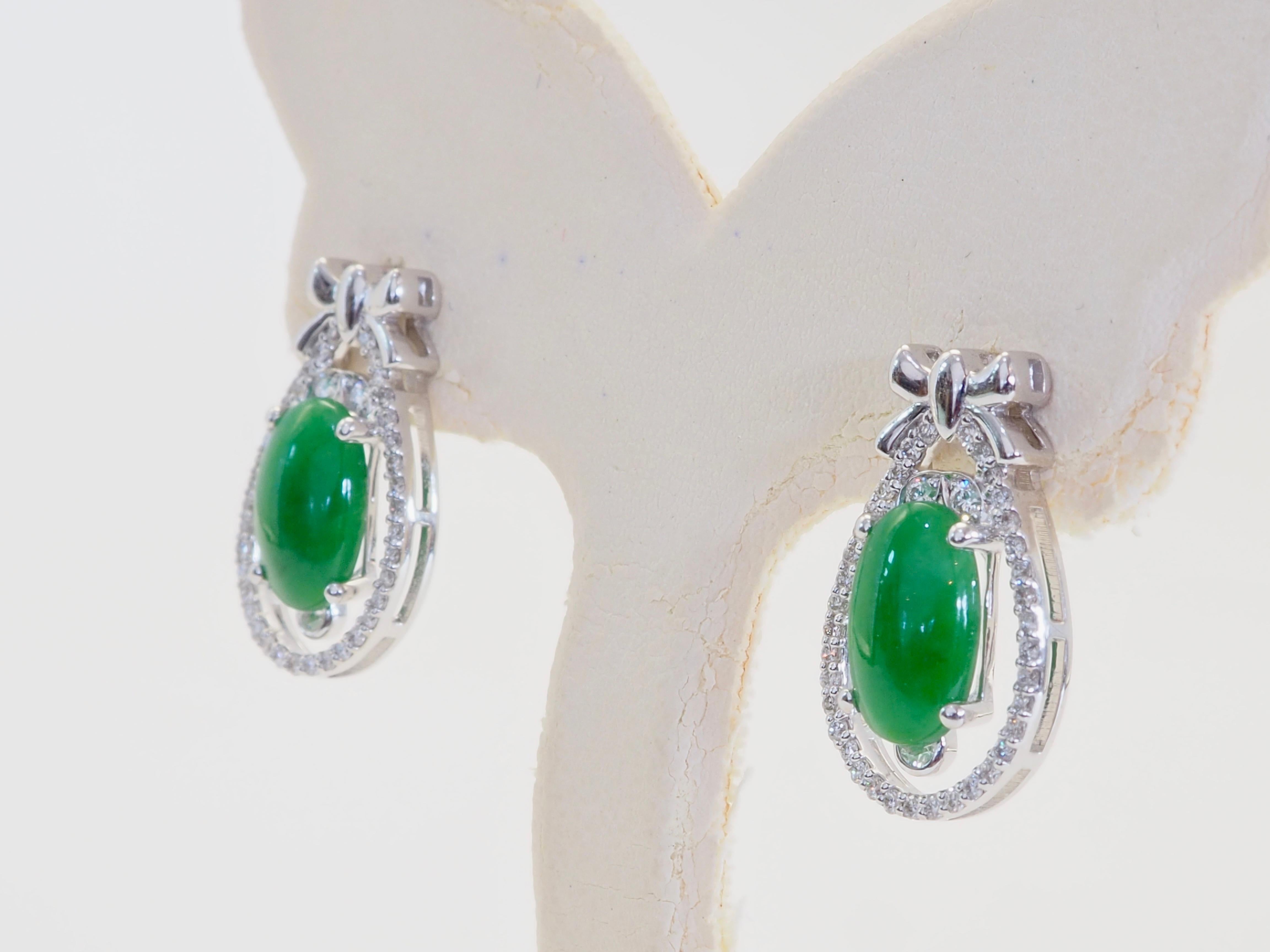 Ein leuchtendes Paar Ohrstecker mit birmanischem Jadeit vom Typ A, insgesamt ca. 3 Karat, in einem lebhaften apfelgrünen Farbton, der für seine Frische und Transluzenz geschätzt wird. Jeder ovale Jadeit-Cabochon wird von einem zarten tropfenförmigen