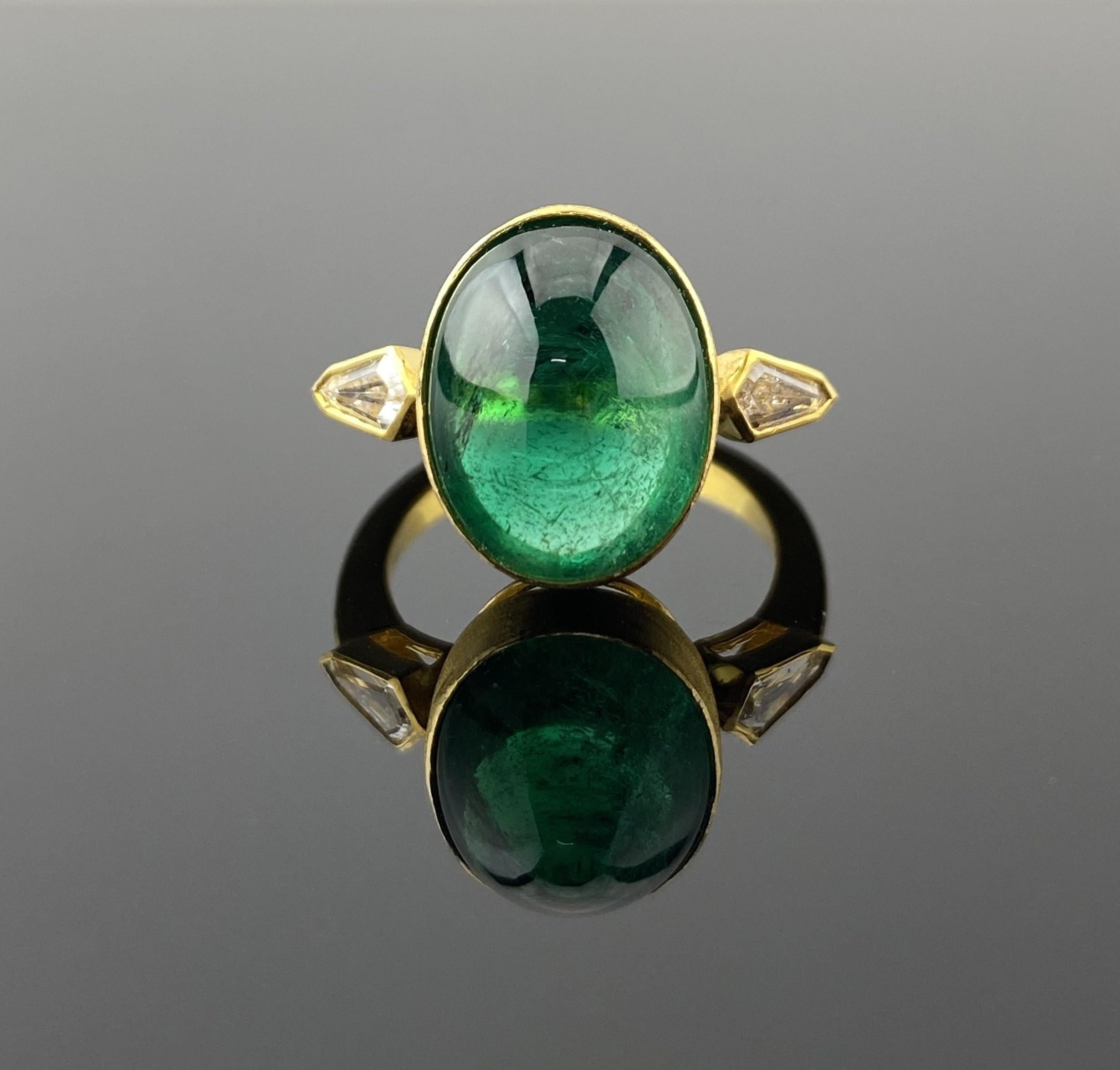 This ring showcases a vivid certified 8.14-carat oval cabochon emerald .  Set in 18K yellow gold (5.09 grams), the emerald is flanked by two kite-cut diamonds totaling 0.41 carats, adding an art-deco feel to the jewel.

With a gross weight of 6.34