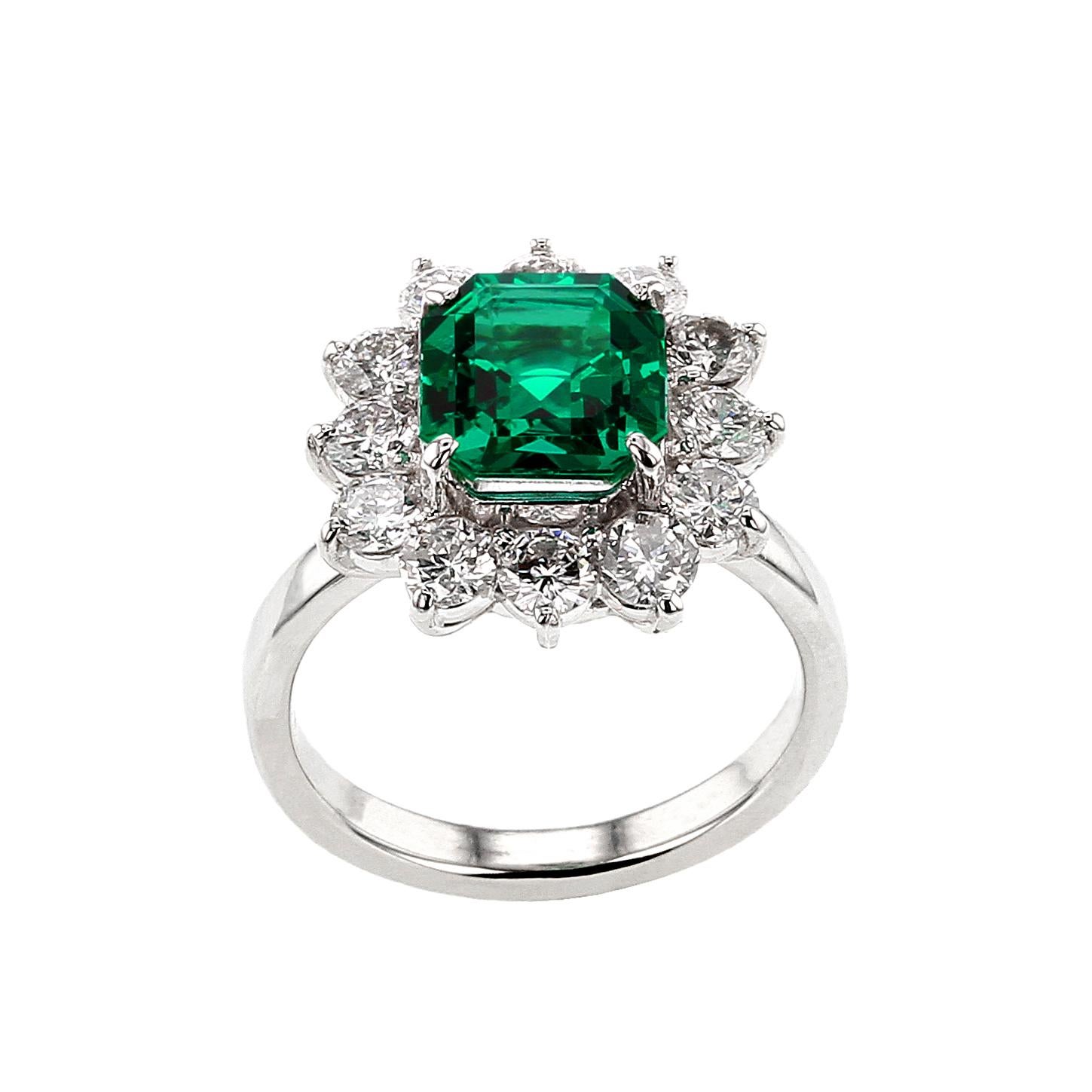 An exceptional and rare cluster ring centered with a very fine quality square shape step-cut no oil emerald weighing well over two carats accented with a circular row of round, brilliant-cut diamonds, set in Platinum. The emerald accompanies a