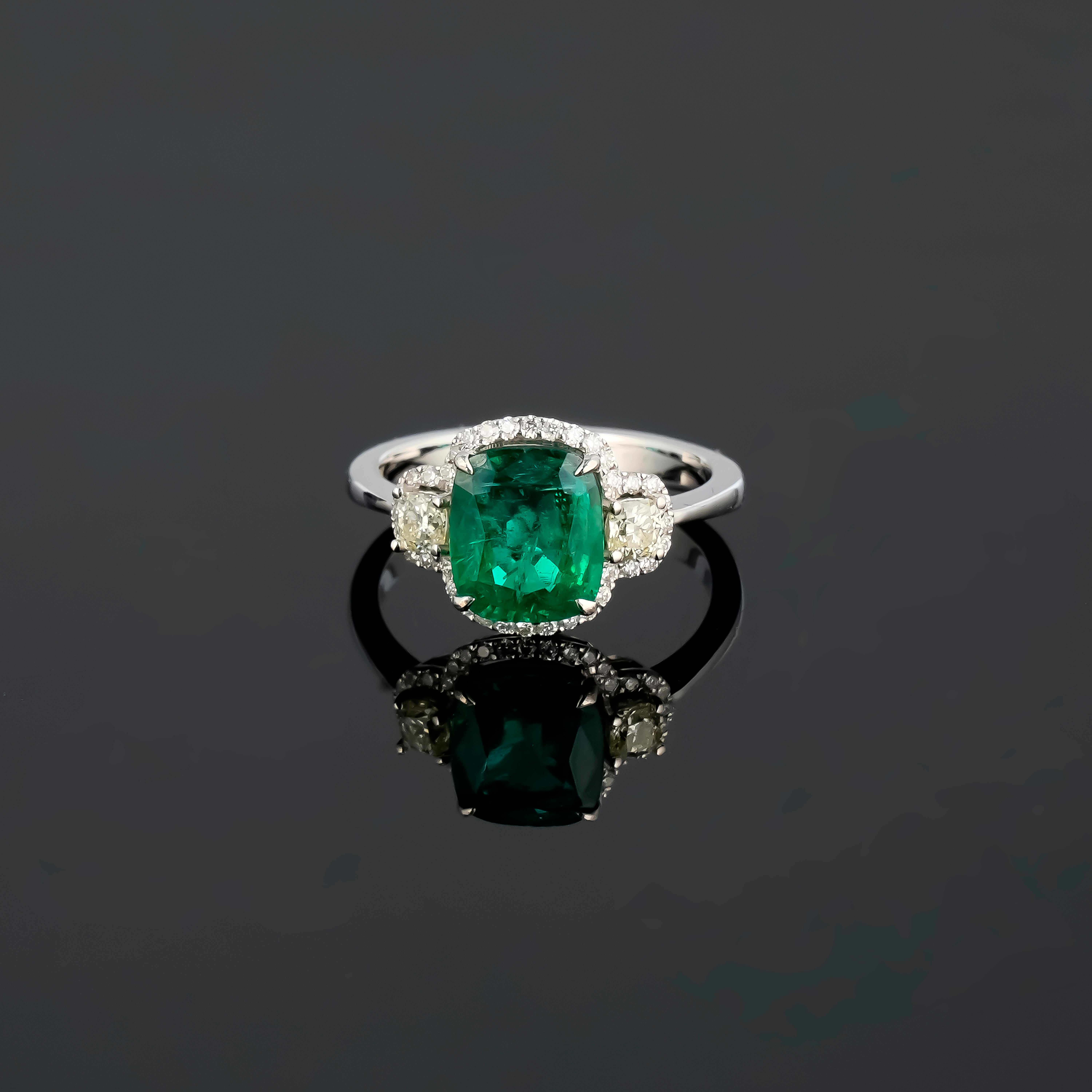 Ein schöner, zertifizierter 2,03 Karat kissenförmiger sambischer Smaragd Verlobungsring, verziert mit 0,28 Karat kissenförmigen Diamanten an den Seiten und 0,21 Karat runden Diamanten. Der Smaragd ist durchsichtig, hat eine schöne, lebhafte grüne