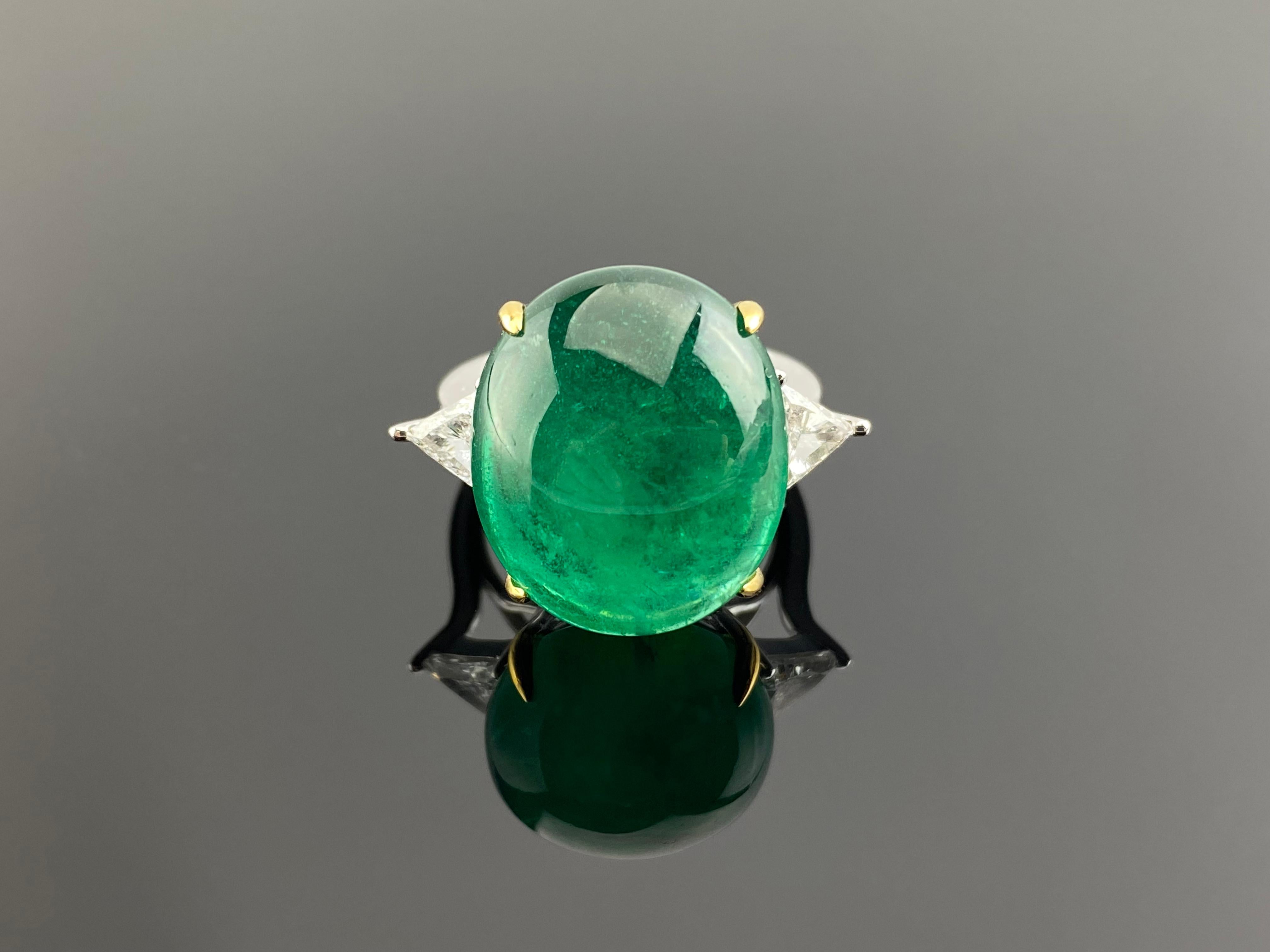 Make a statement with this stunning 20.47 carat Emerald Cabochon and 0.71 carat trillion shaped VVS quality white Diamond engagement ring. The natural Emerald originates from Zambia, and has a beautiful vivid green color, and is not treated. The