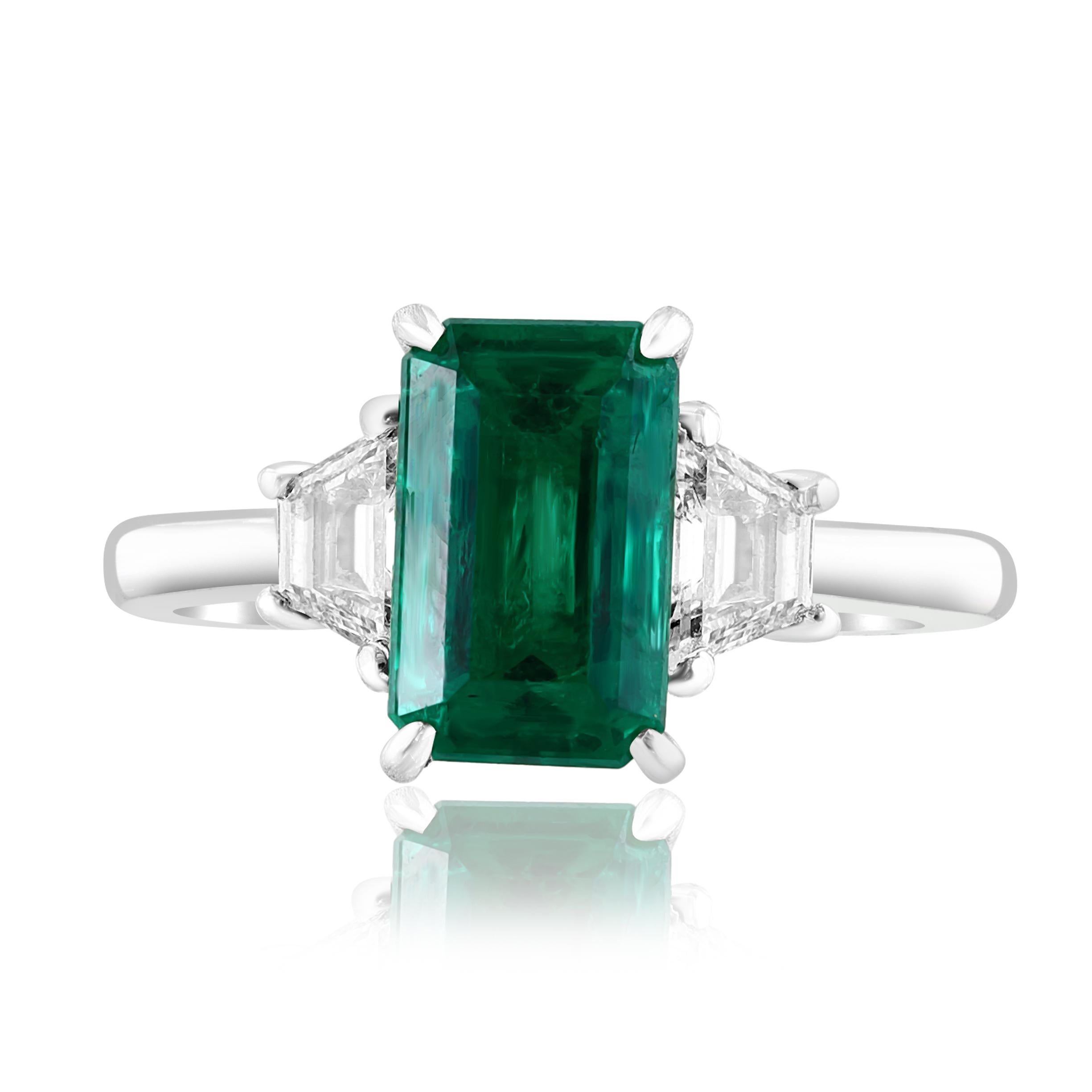 A stunning well-crafted engagement ring showcasing a 2.08-carat certified emerald-cut vivid green emerald from Colombia. Flanking the center diamond are perfectly matched 2-step cut trapezoid diamonds weighing 0.55 carat in total, set in a polished