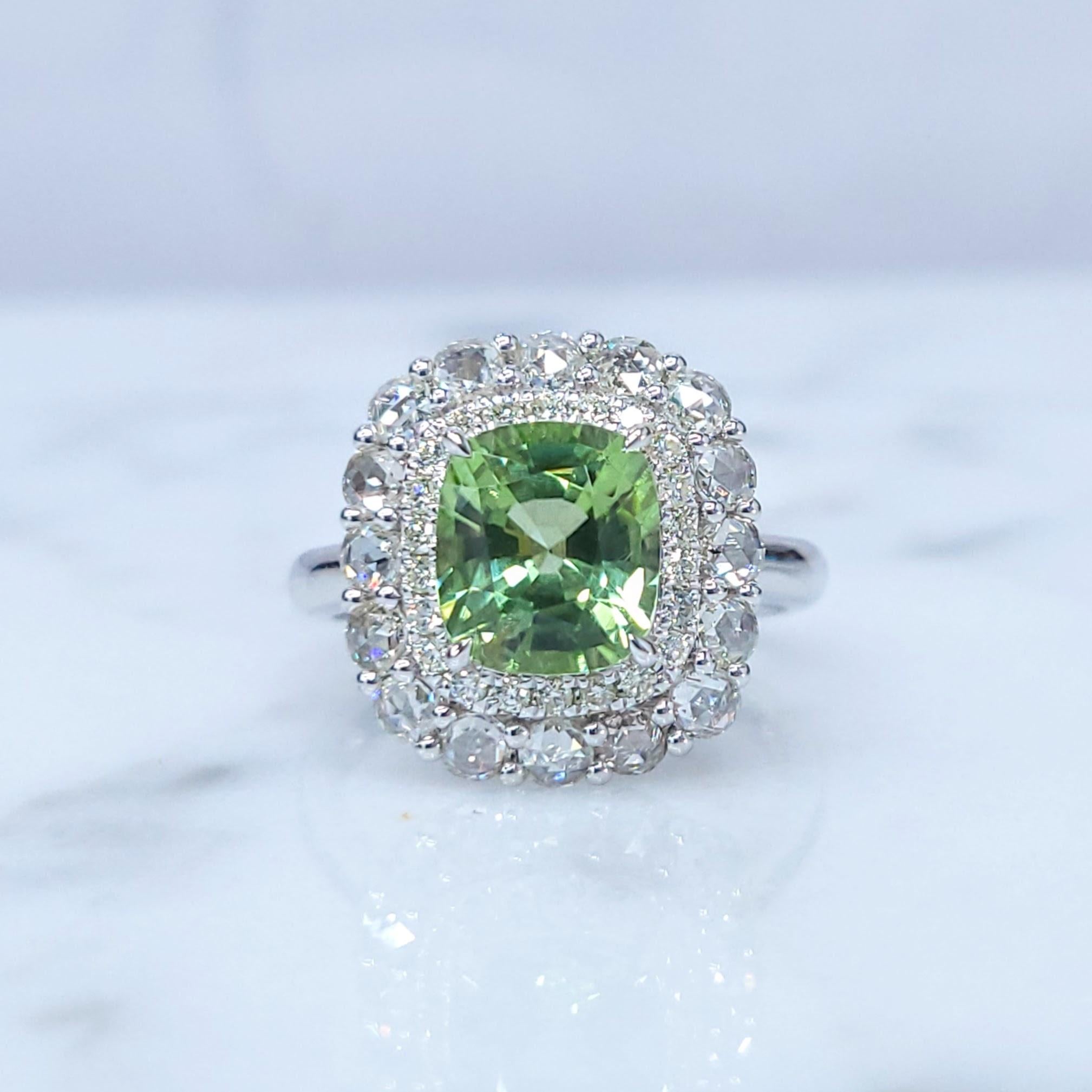 This exquisite ring features a captivating 2.10-carat green peridot, a gemstone known for its vibrant color and clarity. The peridot, originating from Burma, is set in a classic four-prong setting, allowing its vivid yellow-green hue to