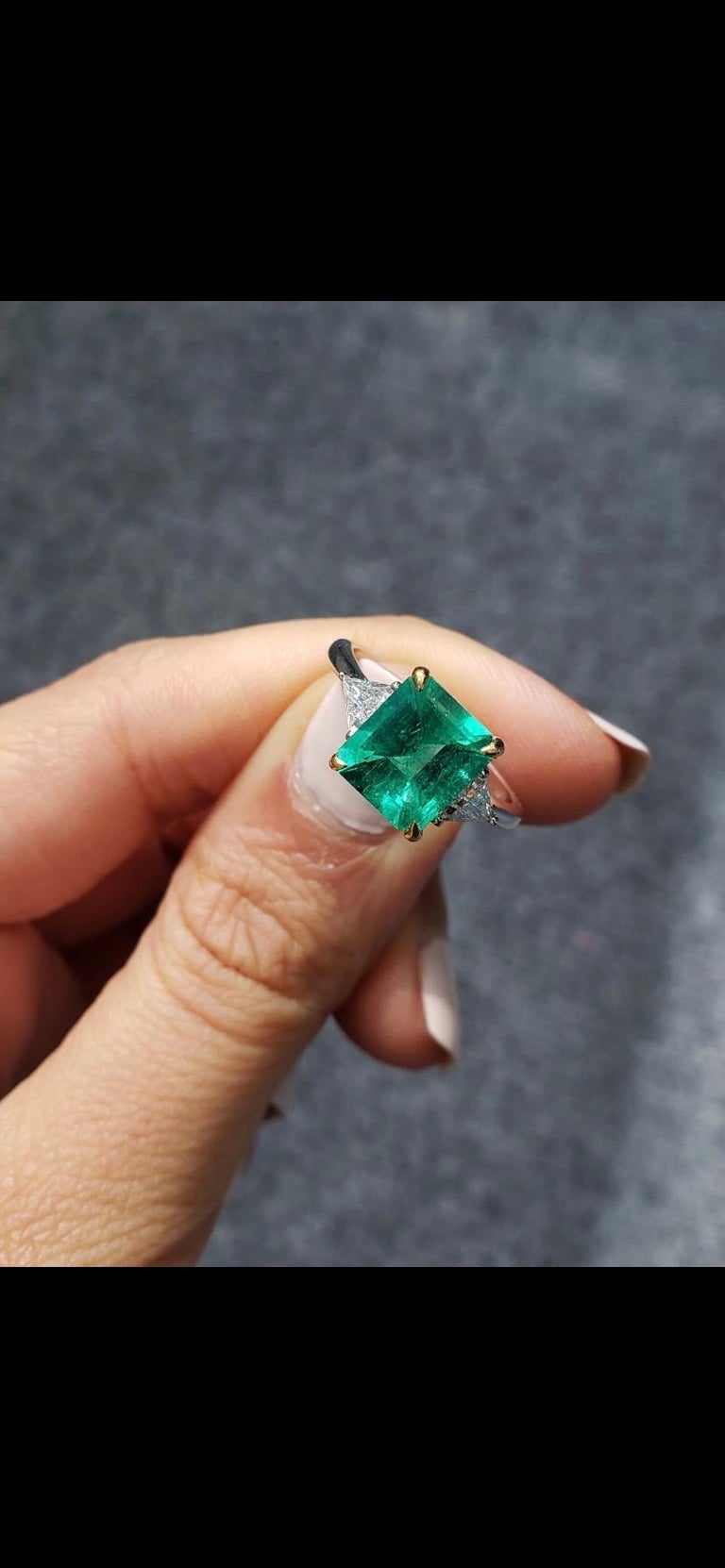 A certified vibrant, vivid green 2.36 carat emerald cut Colombian Emerald and 0.32 carat VS quality Trillion Diamond three stone, engagement ring. The stones are set in 18K White Gold. Currently sized at US 7, can be altered. 
We accept