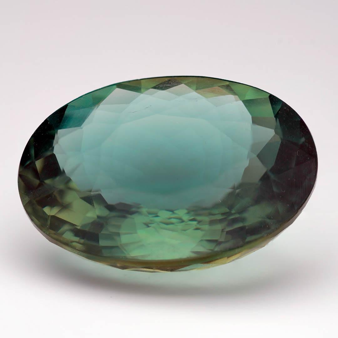 Unveil nature’s palette with this Apatite gemstone, faceted into a large oval cut that radiates deep teal and forest green tones. This captivating gem exhibits exceptional brilliance and depth, offering a dynamic play of color that shifts under