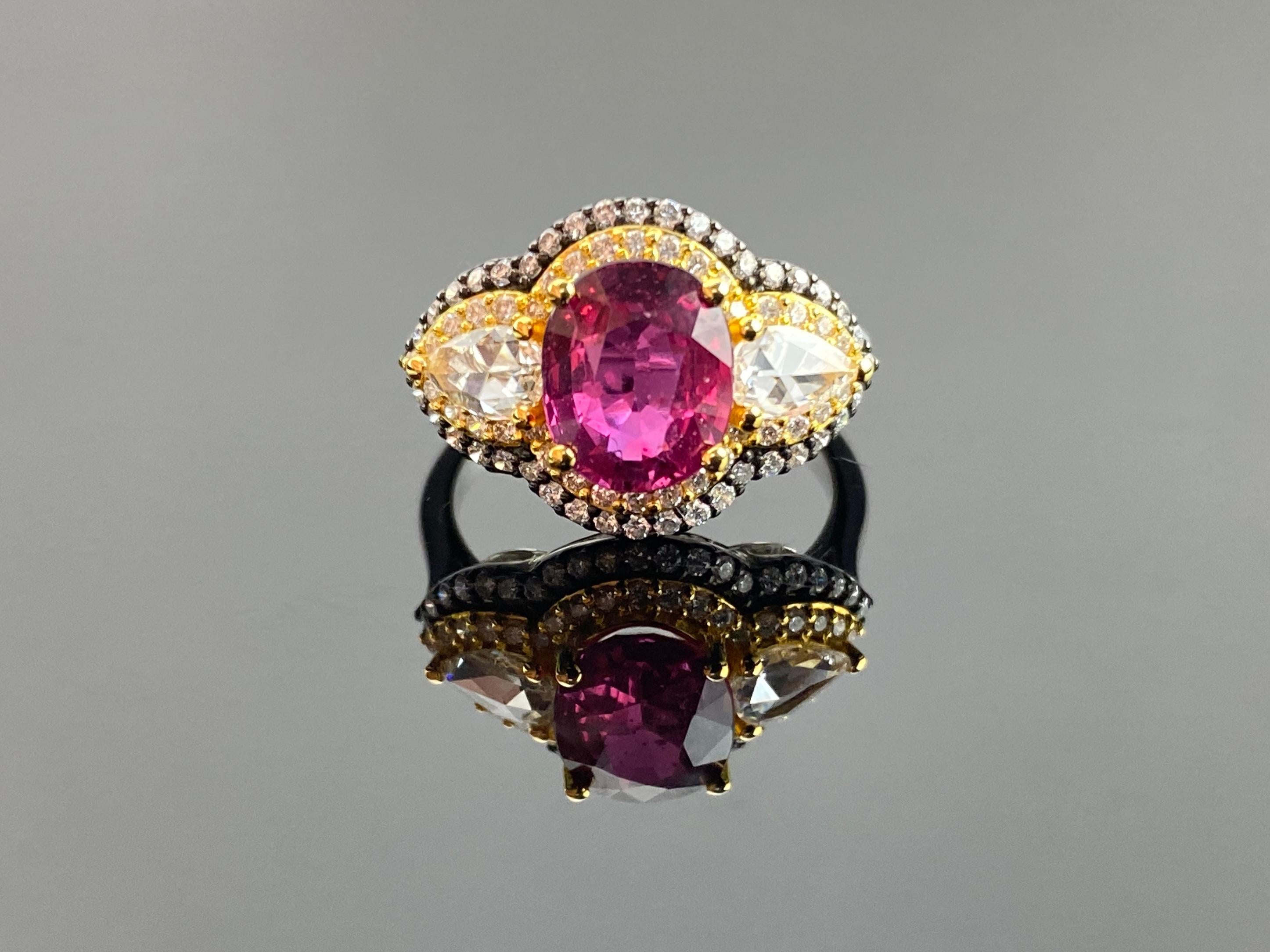 A stunning 2.59 carat certified Ruby and Diamond three stone engagement ring, with 0.42 carat pear shape rose cut Diamonds and 0.6 carat round Diamonds surrounding it, all set in solid 18K Gold. The center stone Ruby is oval shaped, with a stunning