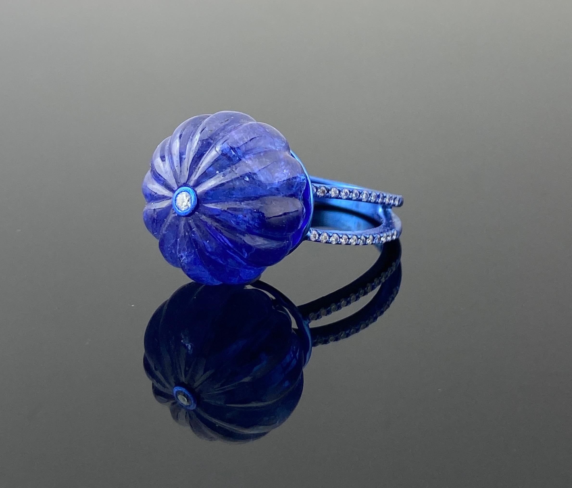 Bague de cocktail de style art-déco avec une tanzanite sculptée de 26,05 carats et des diamants de 0,25 carat. La bague est en or blanc massif 18 carats avec un revêtement en rhodium bleu et des diamants sur l'anneau, ce qui lui confère un aspect