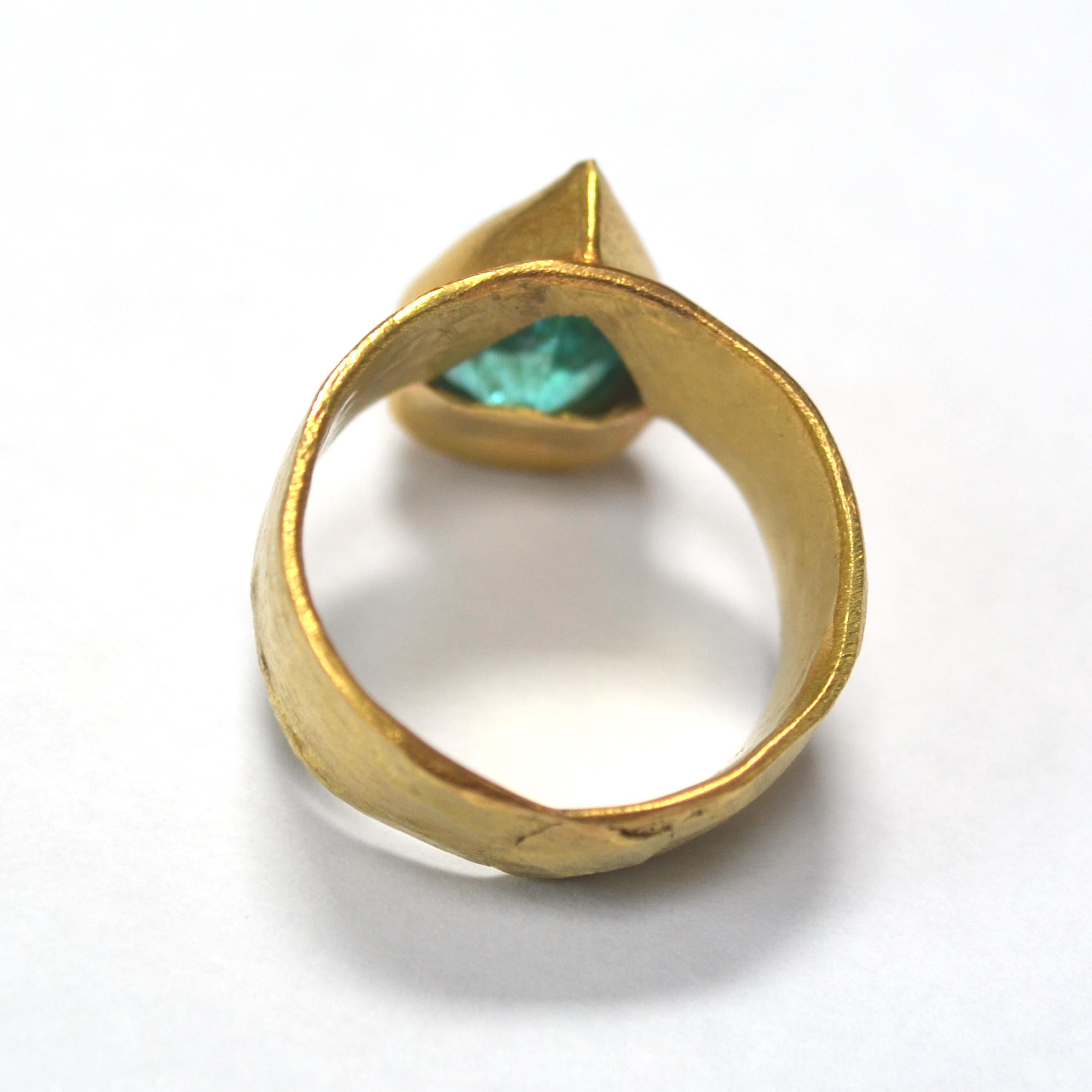 18k yellow Gold wide hammered textured ring with stunning sea-blue Paraiba type Tourmaline. Like a drop of Mediterranean Sea, the incandescent glow that comes from within the stone means you can be reminded of the warmth of a Greek Island or Italian