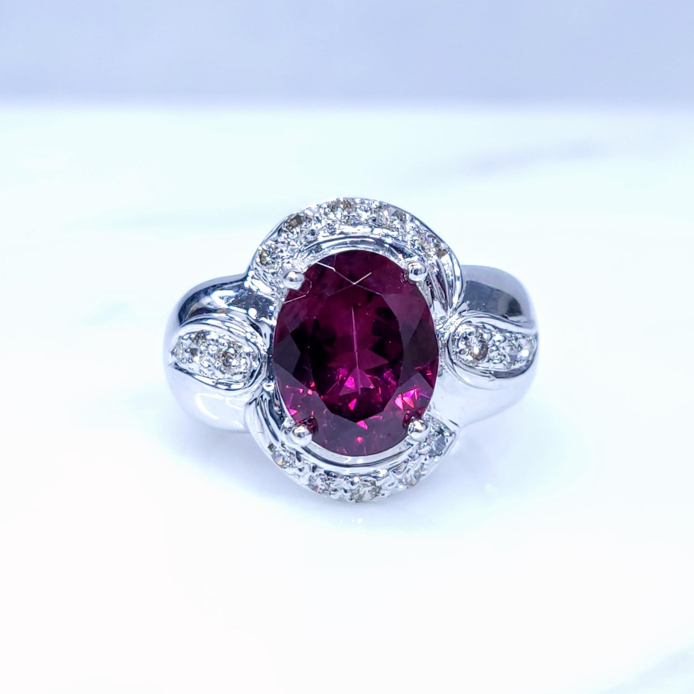 This exquisite ring features a captivating No Heat oval-cut Sri Lankan ruby, weighing 3.00 carats. The ruby's vibrant red color, characteristic of Sri Lankan rubies, is complemented by a sparkling halo of diamonds, totaling 0.28 carats. The ring is