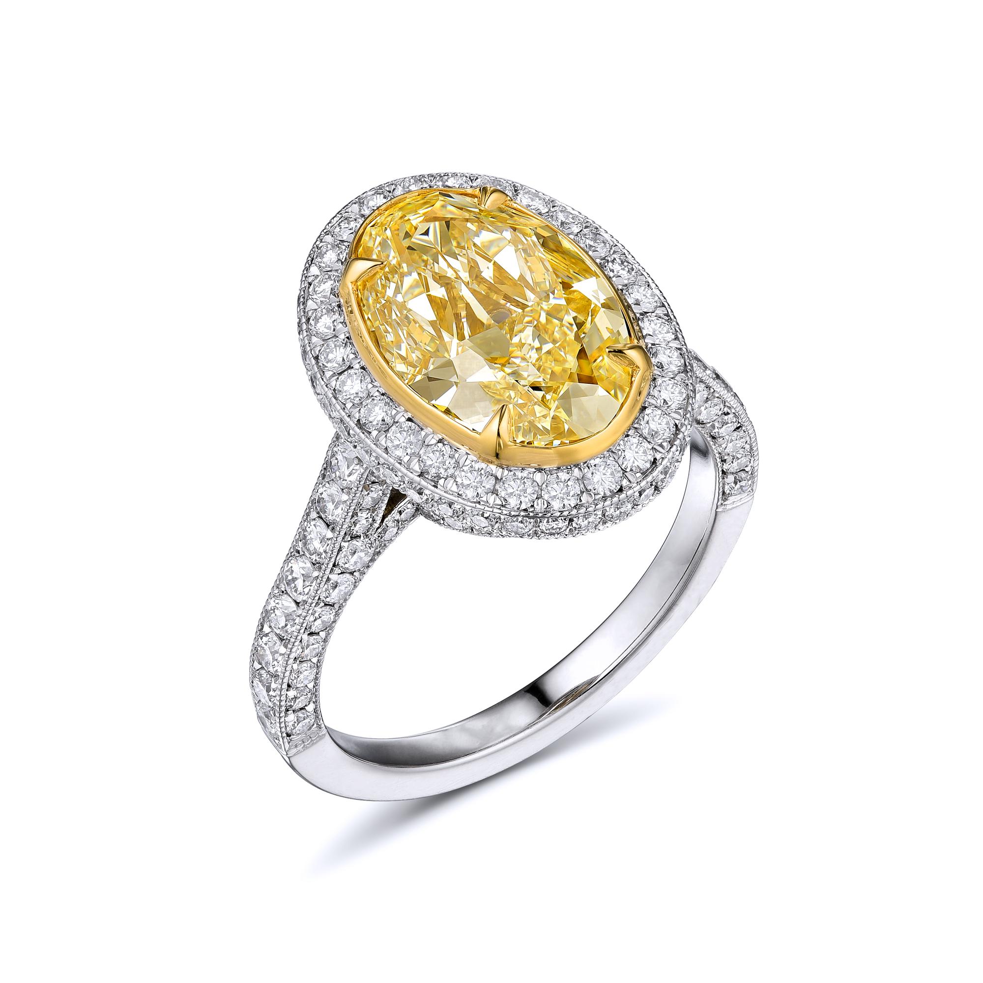Diamond ring with EGL Certificate, no. US311986601D. Center stone: 3.17ct/ VS2 Oval cut fancy yellow diamond, 12.1 x 8.09 x 5.00 mm. 
Side stones: 1.18ct/ E-F-G VS2-SI2 Brilliant round diamonds. Total carat weight: 4.35ct. Metal: Platinum and 18K