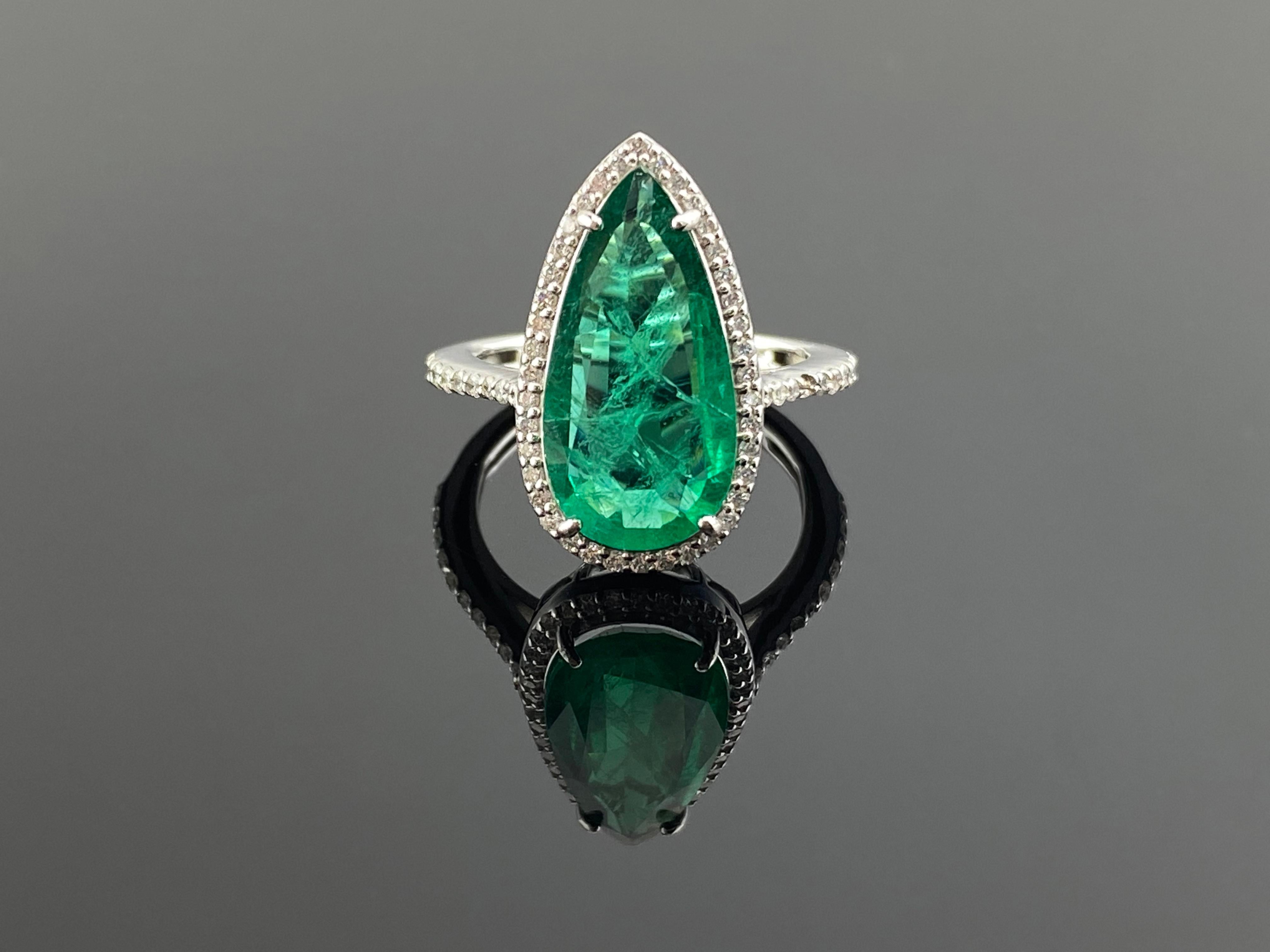 A stunning Halo Ring featuring a Certificate 3.20 Carat pear shaped natural Zambian Emerald and 0.44 Carats of Diamond set in solid 18K Gold. People have admired emerald’s green for thousands of years. Emeralds have always been associated with the