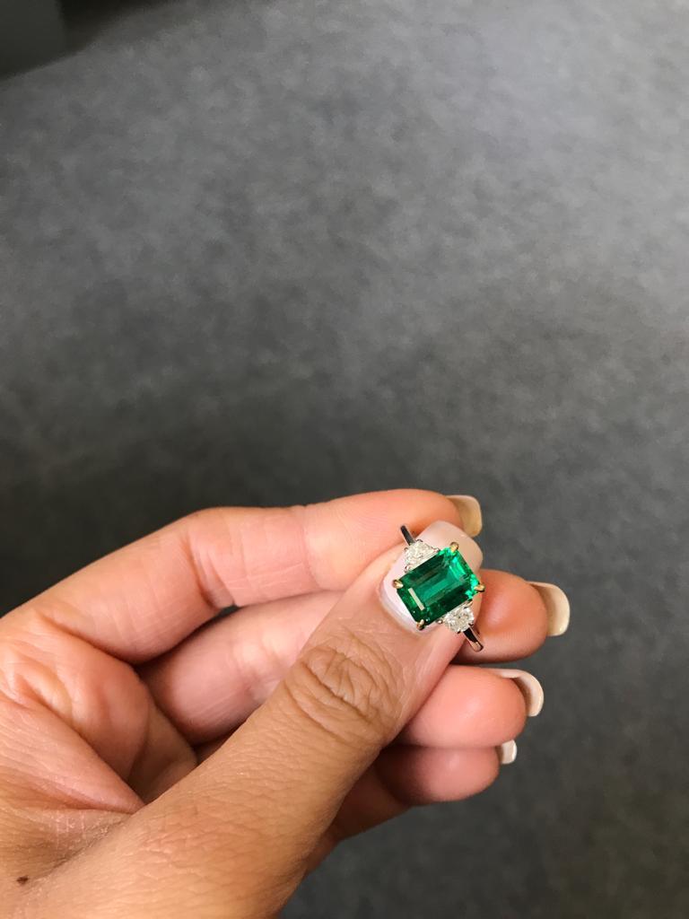 A classic three stone ring, with a 3.20 carat high quality and great colour emerald cut Zambian Emerald centre stone and 2 half-moon 0.33 carat side stone Diamonds. Currently a ring size US 6, but we can resize the ring for you without additional