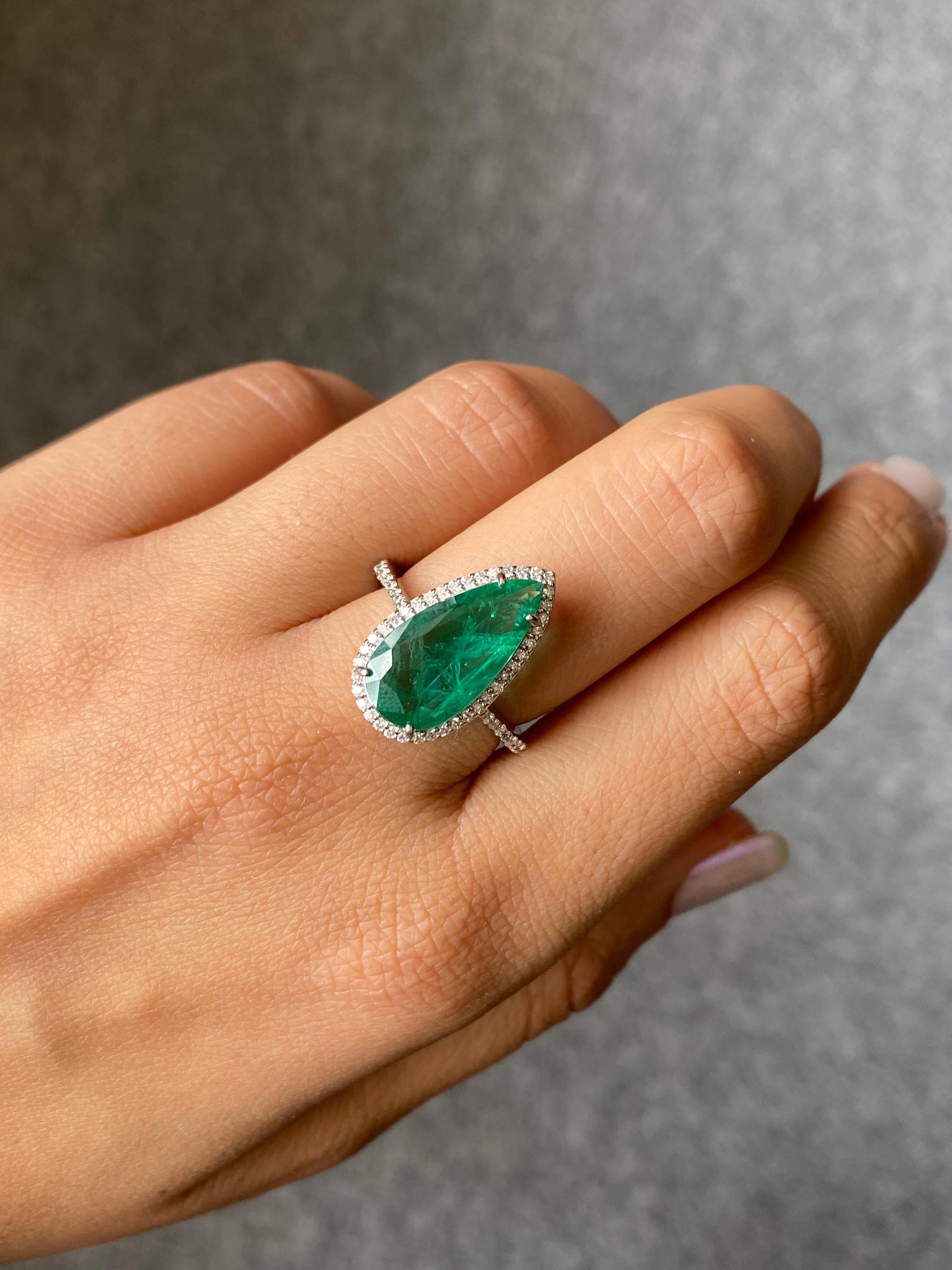 A classic 3.20 carat pear shaped Zambian Emerald, with a 0.4 carat White Diamond halo - all set in solid 18K White Gold. The Emerald is natural, completely transparent with a great cut and vivid green color. The ring is currently sized at US 7, can