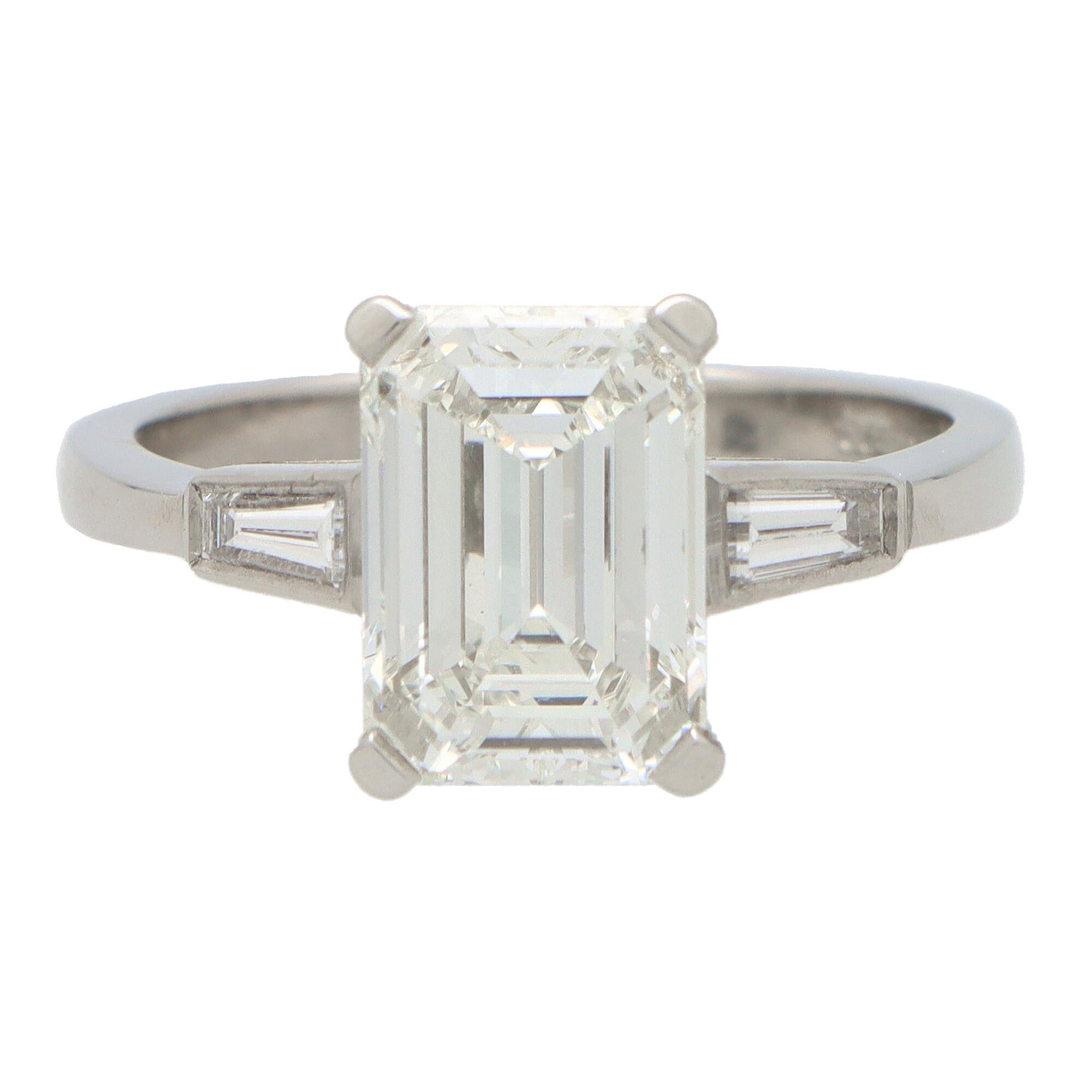 A beautiful certified emerald cut diamond ring set in platinum.

The ring is centrally set with an outstanding certified 3.20 carat emerald cut diamond which is securely claw set to centre. Siding the central stone are two perfectly tapered baguette