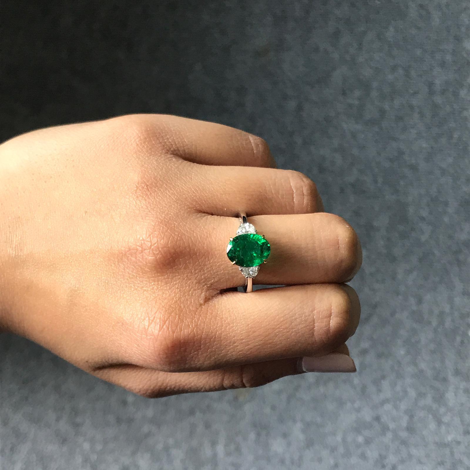 A classic three stone ring, with a 3.22 carat high quality and great colour oval cut Zambian Emerald centre stone and 2 half-moon 0.36 carat side stone Diamonds. Currently a ring size US 6, but we can resize the ring for you without additional cost.