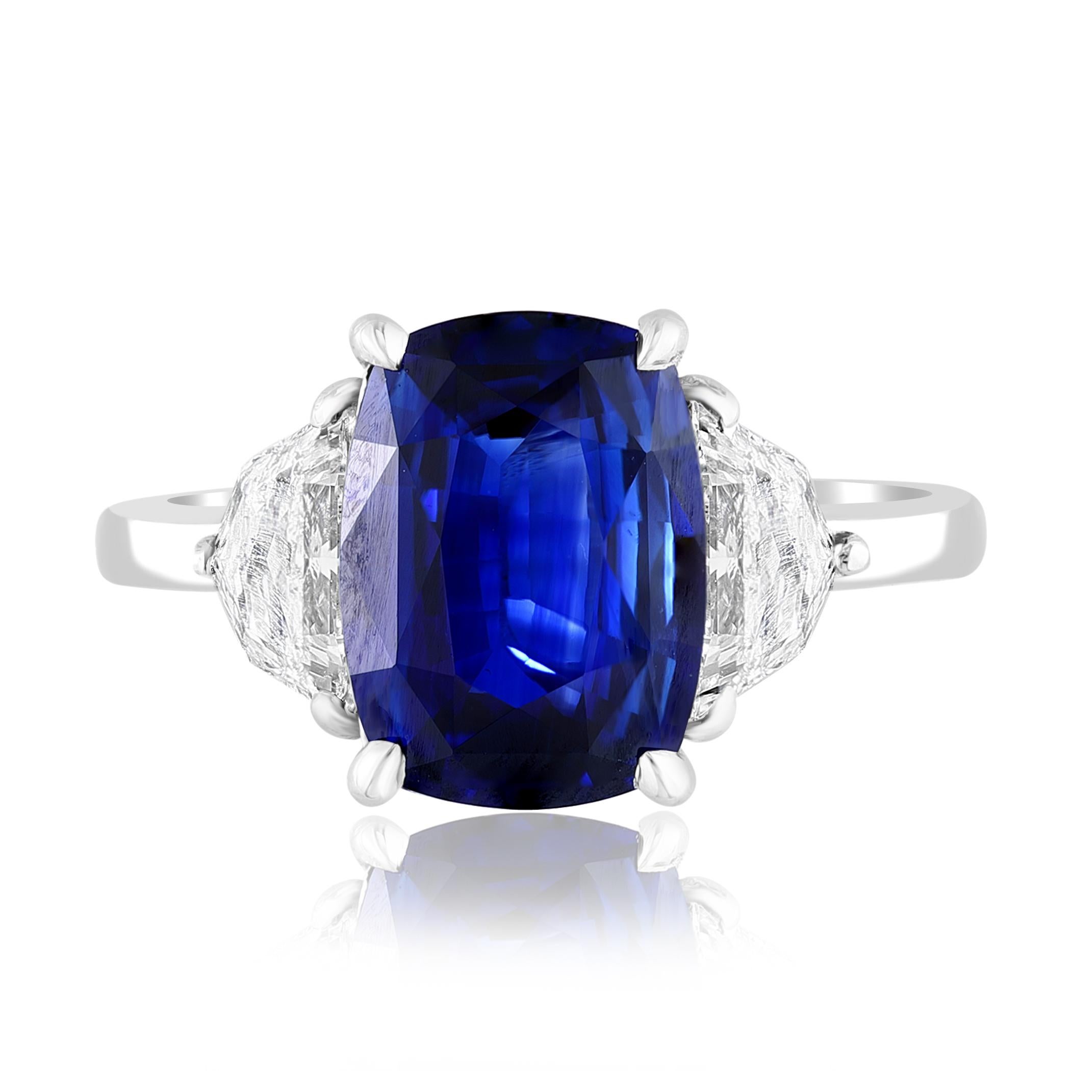 Showcasing Certified Cushion cut, Vibrant color Blue Sapphire weighing 3.54 carats, flanked by two brilliant cut shield diamonds weighing 0.72 carats total. Elegantly set in a polished platinum composition.