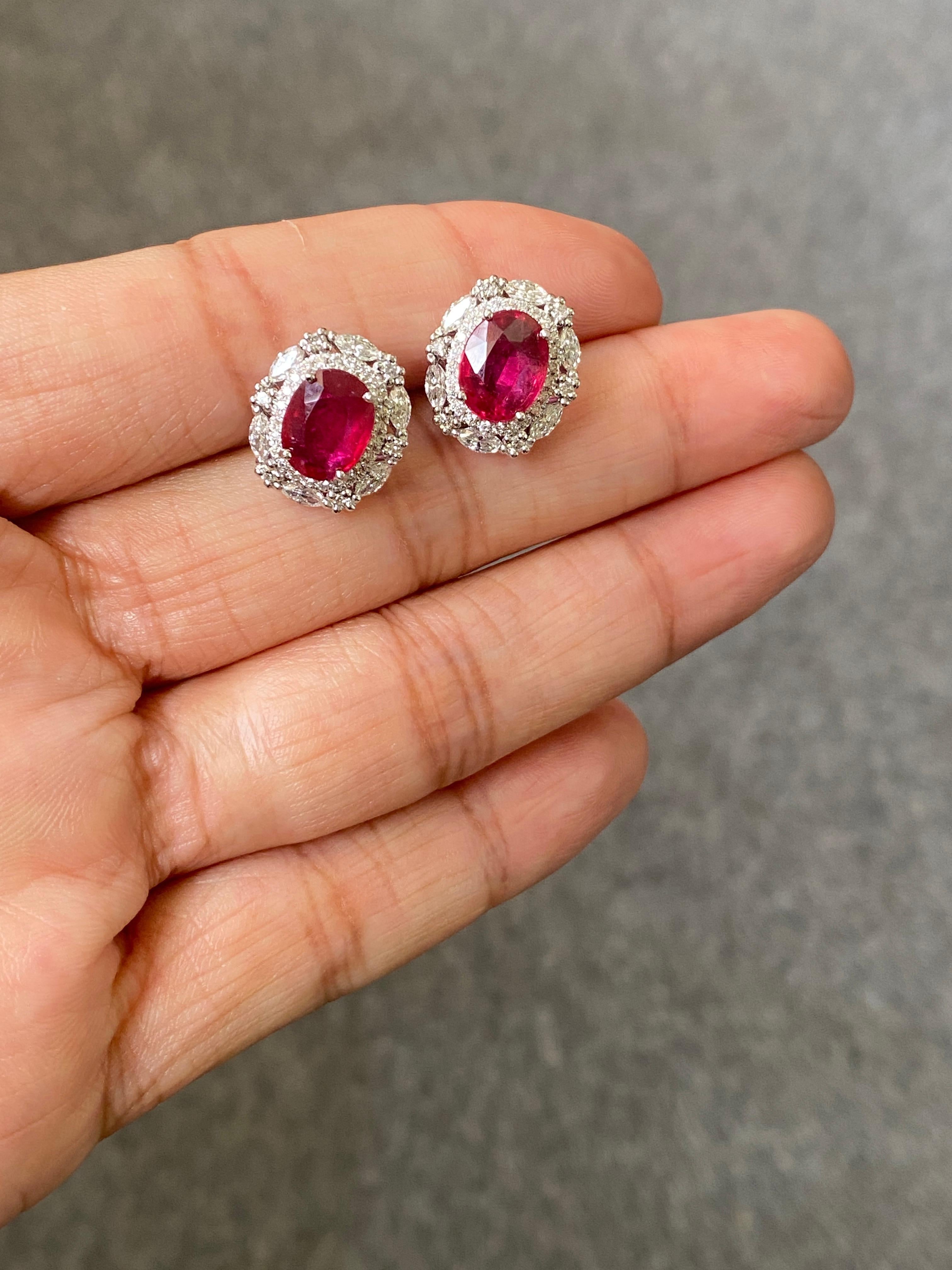 A beautiful pair of natural oval shaped Mozambique ruby earrings, adorned with marquise and round shaped 1.02 carat White Diamonds. The rubies are of top quality, great luster and ideal vivid red color, and transparent. These pair of rubies are