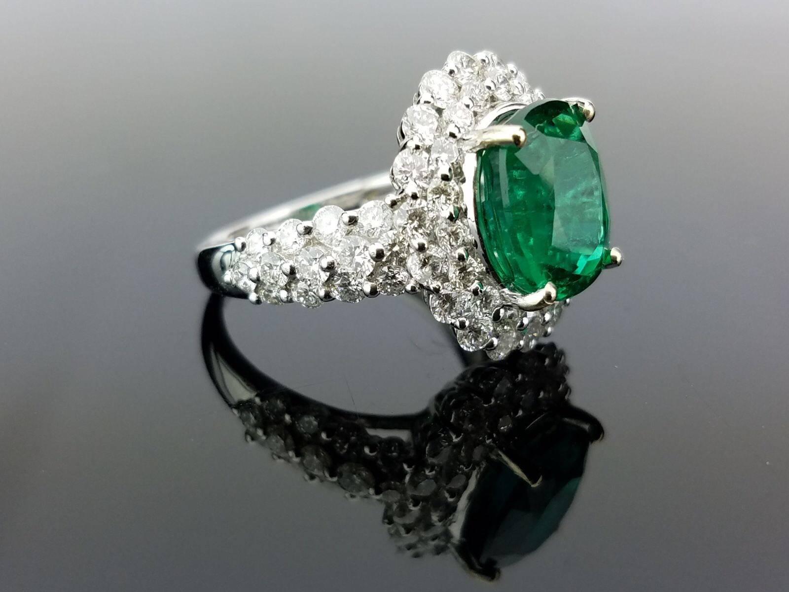 An elegant cocktail ring using a lustrous oval shape Emerald centre stone surrounded by brilliant cut white Diamonds, all set in 18K white gold. 

Stone Details: 
Stone: Zambian Emerald
Carat Weight: 3.91 Carats

Diamond Details: 
Total Carat