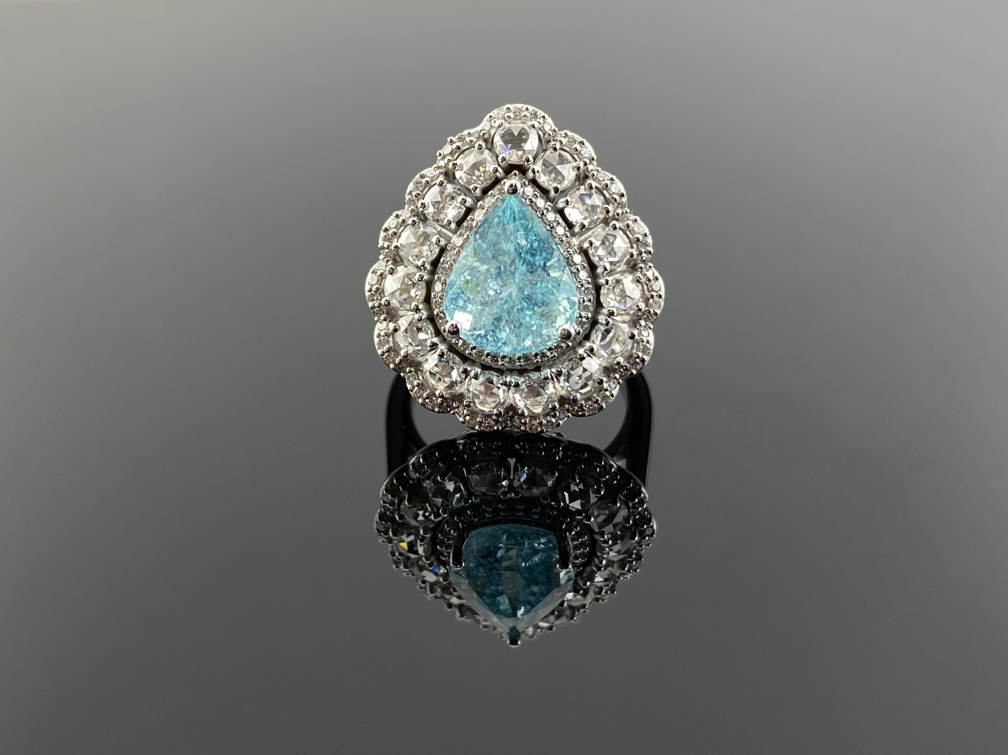 A stunning art-deco inspired 3.96 carat pear shape Paraiba Tourmaline cocktail ring, with 1.34 carats rose cut White Diamonds and 0.44 carat full cut Diamonds, all set in solid 18K White Gold. The ring is currently sized at US 7, can be resized. 
We
