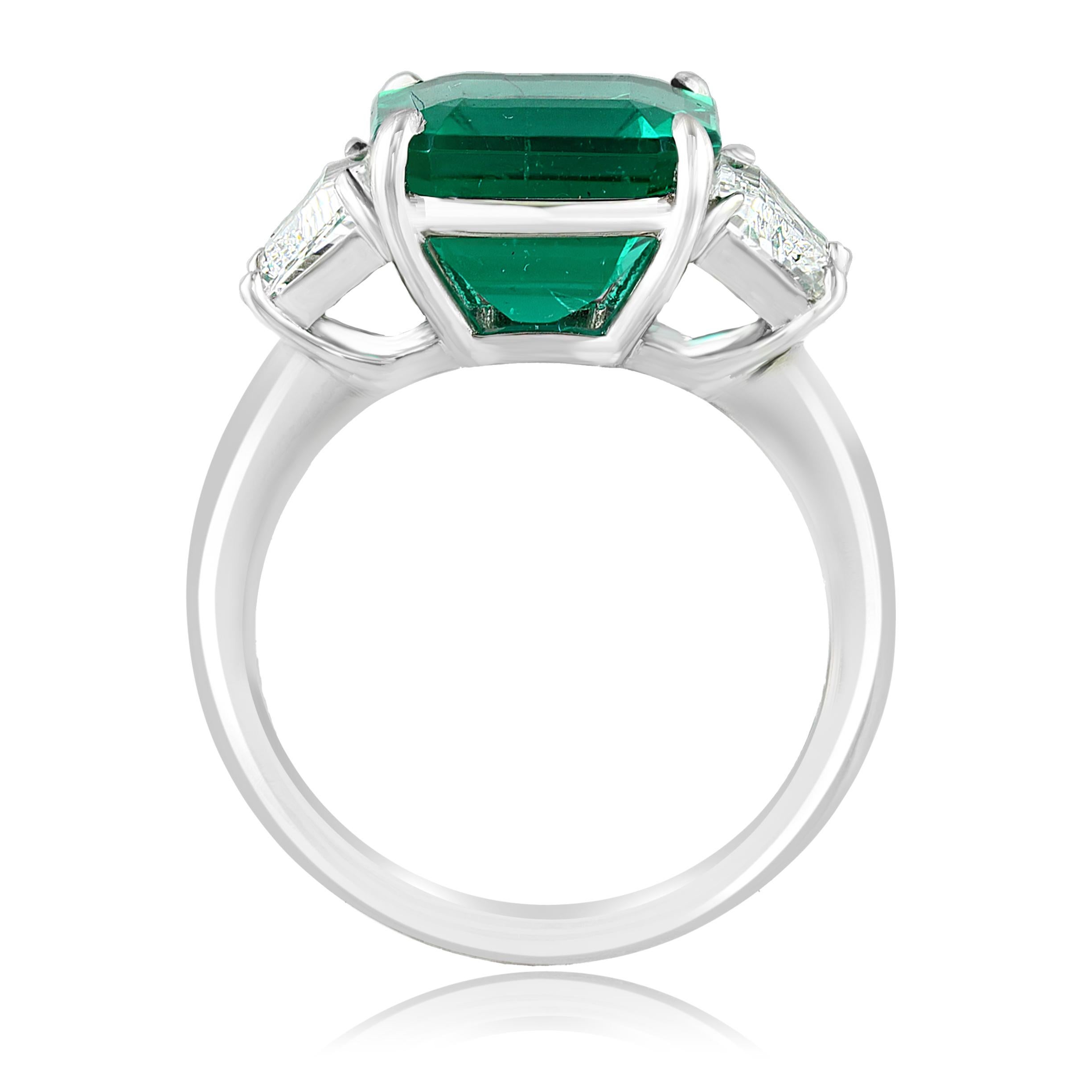 Showcasing Certified Emerald cut, Vibrant color Emerald weighing 4.26 carats, flanked by two brilliant step cut trapezoids diamonds weighing 1.09 carats total. Elegantly set in a polished platinum setting.