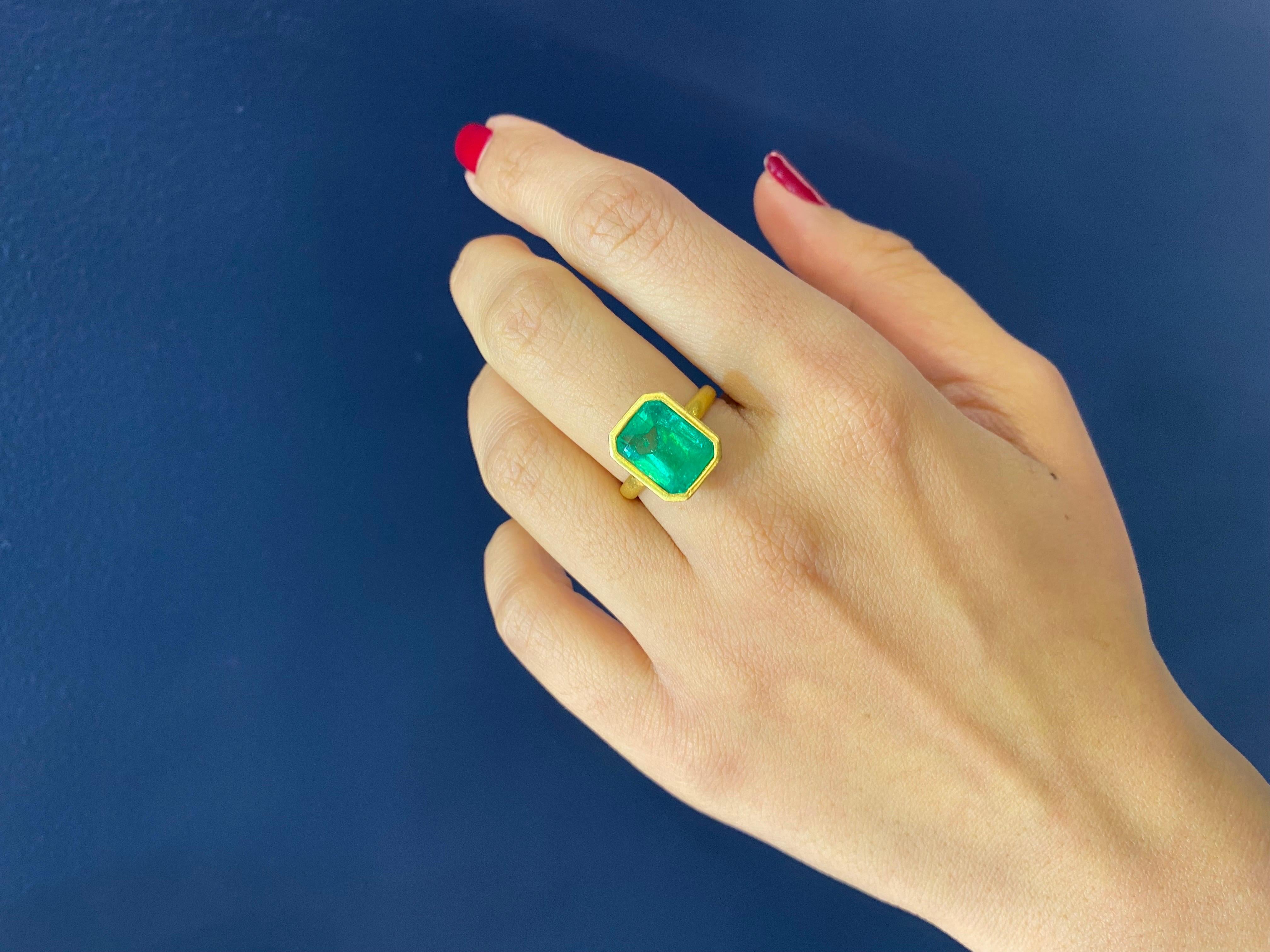 A simple, elegant 4.30 Carat Colombian Emerald ring, bezel set in 18K Yellow Gold. The gold is matte finished, which gives it a very unique look. The Emerald has a beautiful vivid green color and a great luster to it. Currently sized at US6, can be