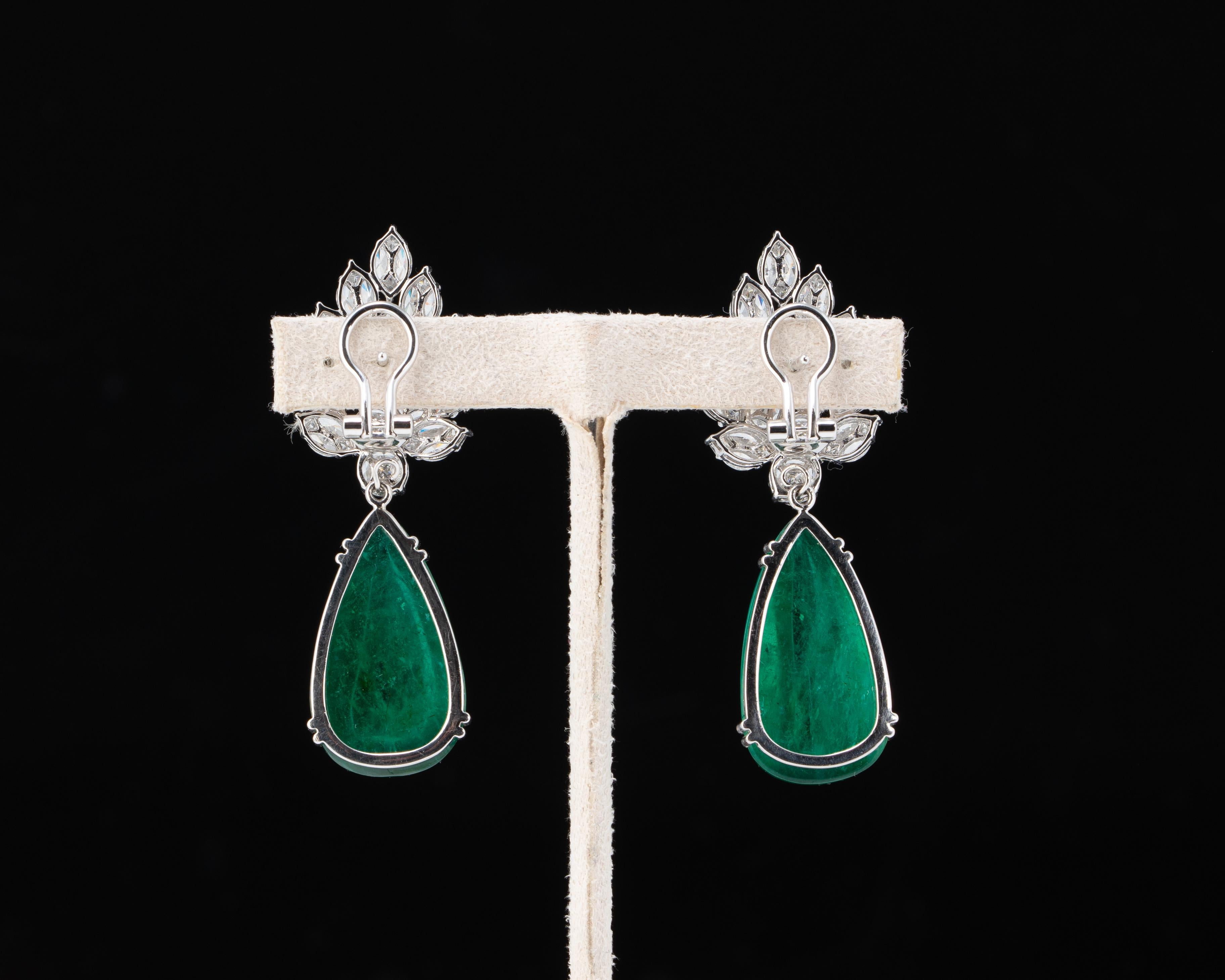 Setzen Sie ein Zeichen mit diesem exquisiten Paar Ohrringe: 44,32 Karat sambischer Smaragde in Birnenform hängen an einer wunderschönen Fassung aus Gold und weißen Diamanten in 18 Karat Weißgold. Die Smaragde sind sauber und transparent und weisen