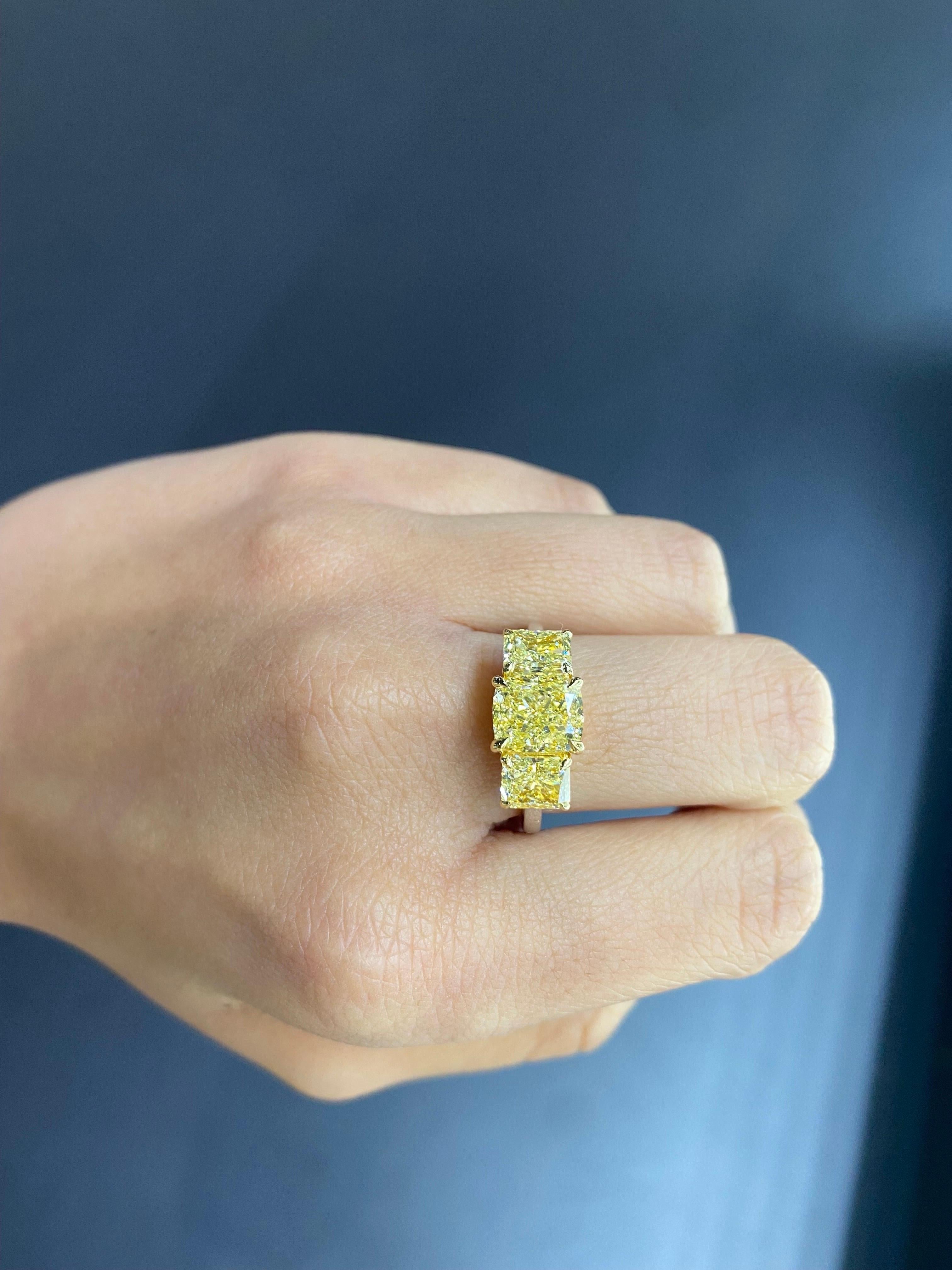 Superbe bague de fiançailles à trois pierres en diamant jaune clair de fantaisie, avec la pierre centrale coussin de 2,51 carats et les pierres latérales de 1 carat chacune, montées en acier massif 18K.  or jaune et or blanc. La taille actuelle est
