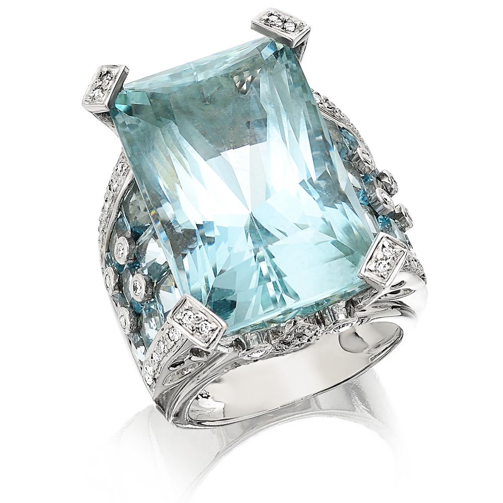 The center aquamarine, a stunning crystal clear blue sea colour, approximate weight 46 carats, surrounding it in decorative and inquisitive borders is another 18 aquamarine, 9 on each side 5.4 carats, there are 76 round brilliant cut glistening