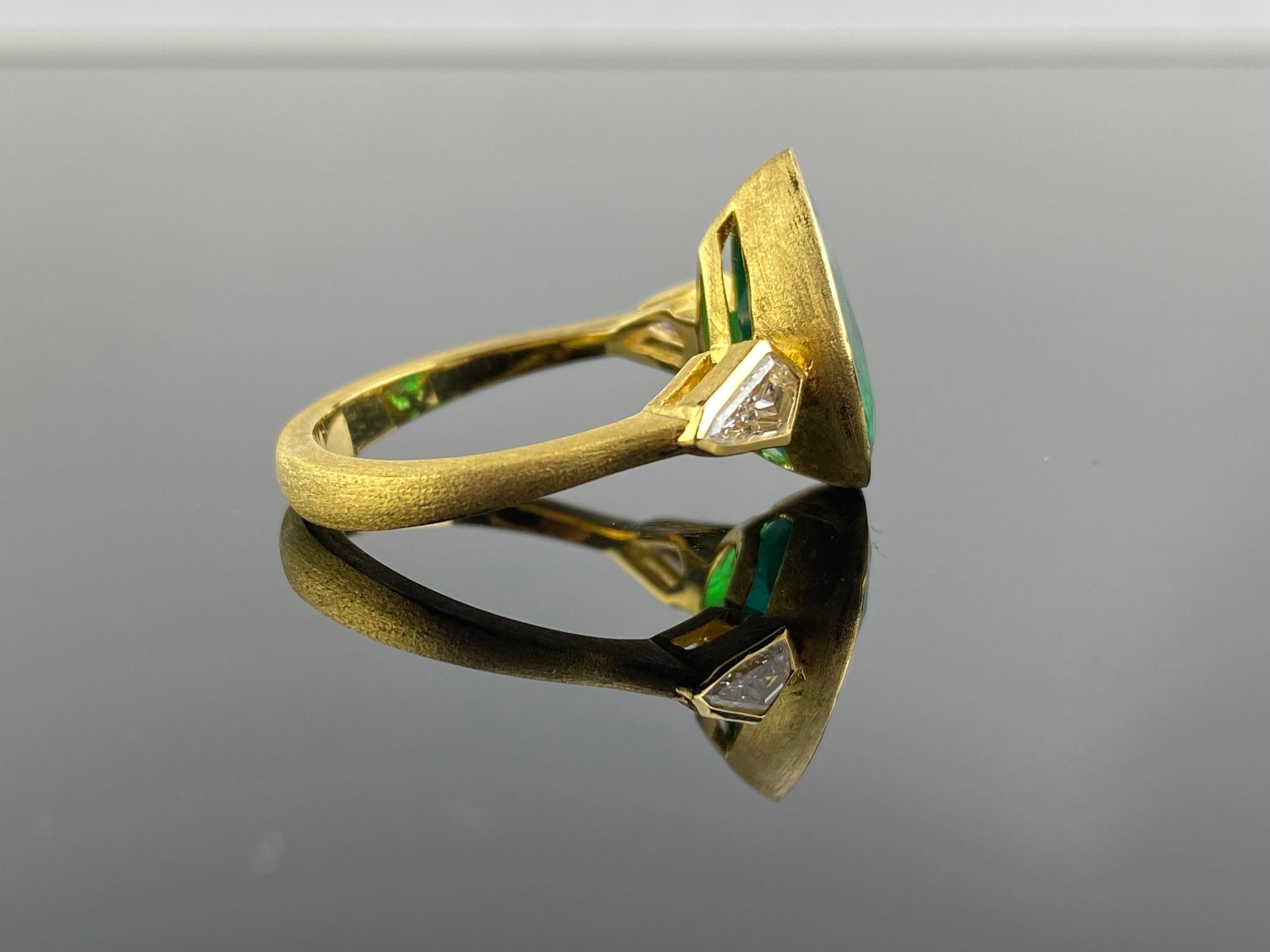 An art-deco looking, natural 4.68 carat pear shaped Zambian Emerald ring with 0.50 carat kite-shaped VS quality Diamond side stone ring. This is a very unique ring, set in matte finish solid 18K Yellow Gold. The center stone in has a stunning vivid