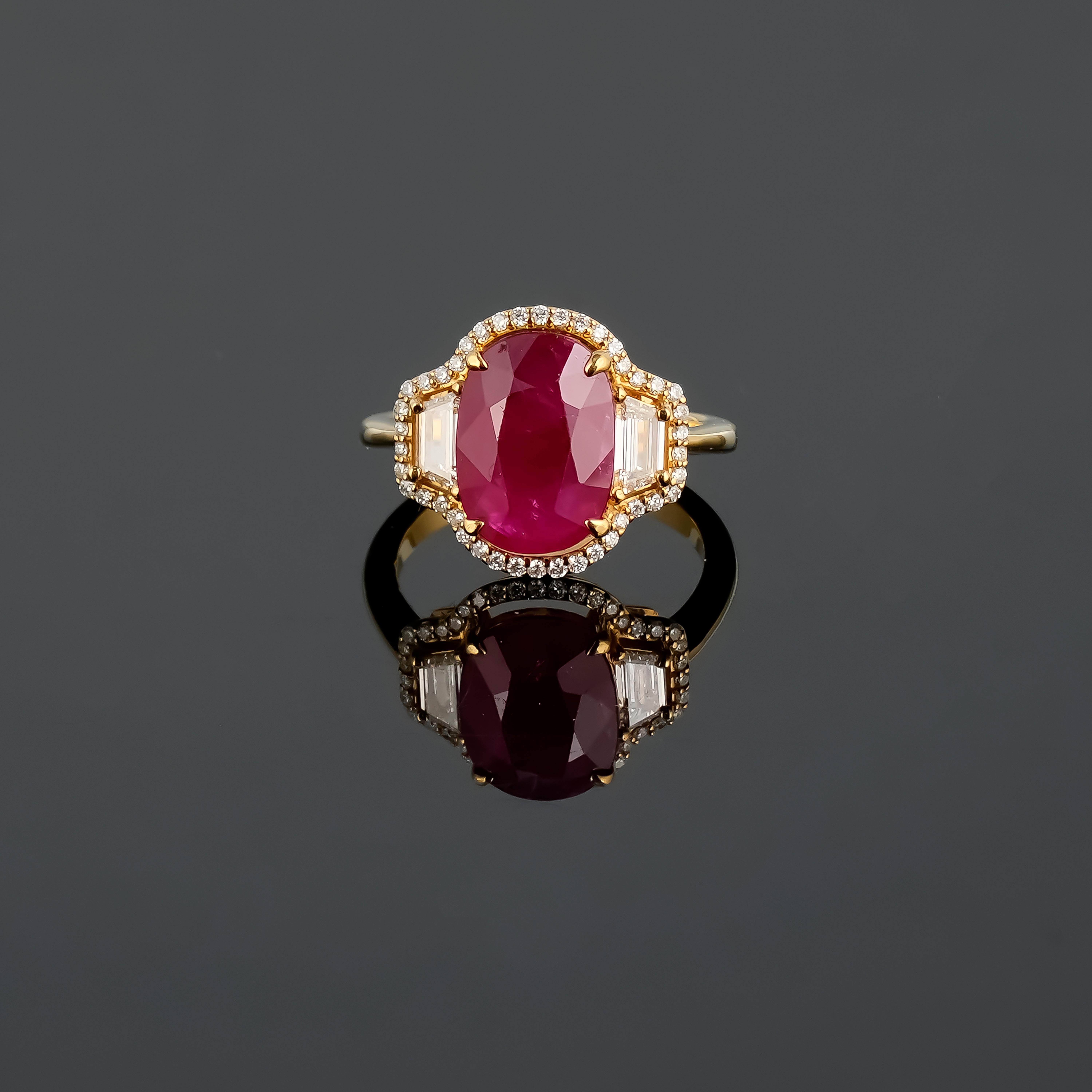 A spectacular oval shaped red heated Burma Ruby commands attention in this extraordinary 18K yellow gold ring. The stoplight-red ruby weighs 4.94 carats, two sleek trapezoid diamonds weighing 0.37 carats, surrounded by smaller round brilliant
