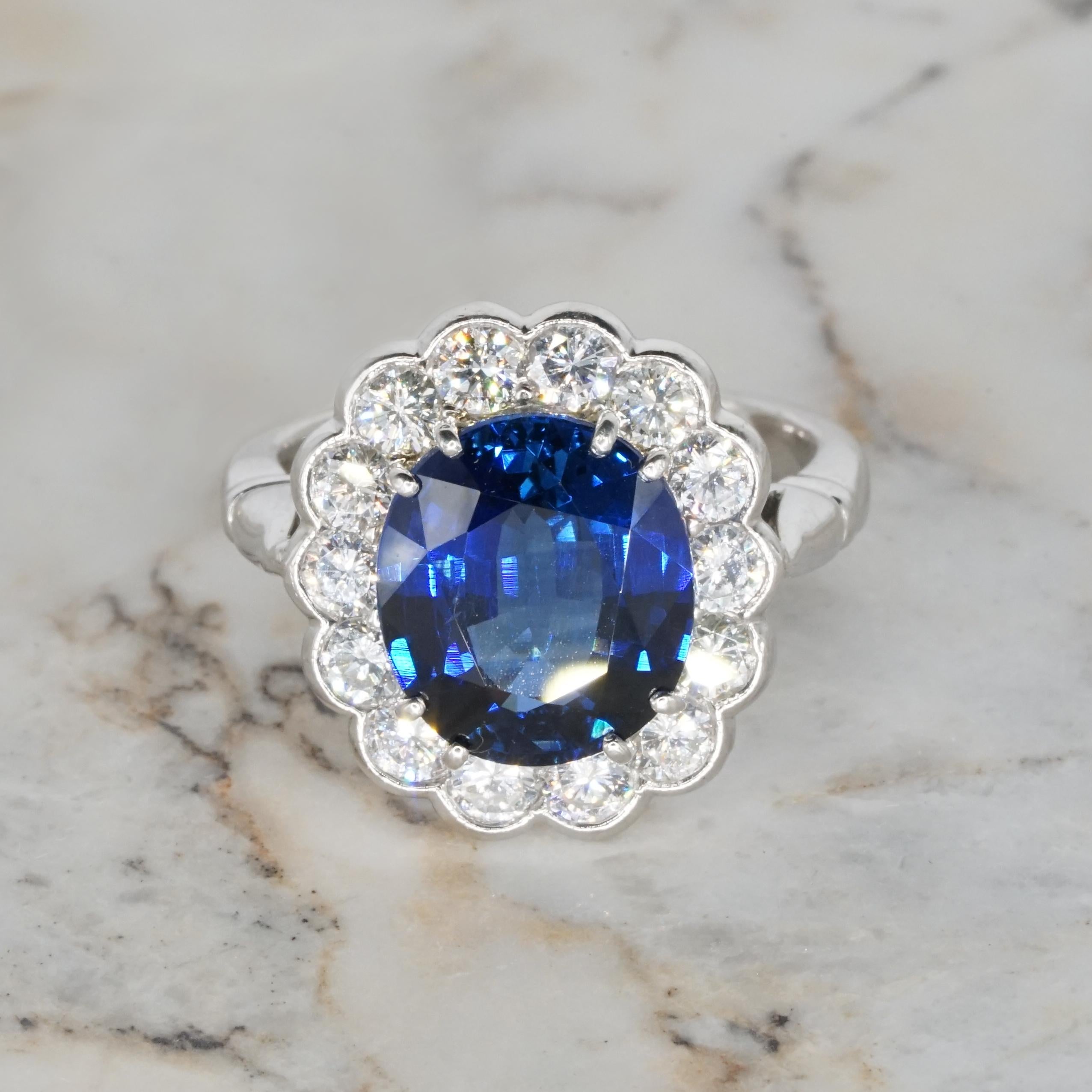 This stunning cocktail ring is the epitome of refined elegance, featuring a mesmerizing oval-shaped blue sapphire at its center. Surrounded by a halo of dazzling diamonds, the design perfectly blends timeless sophistication with modern allure. The