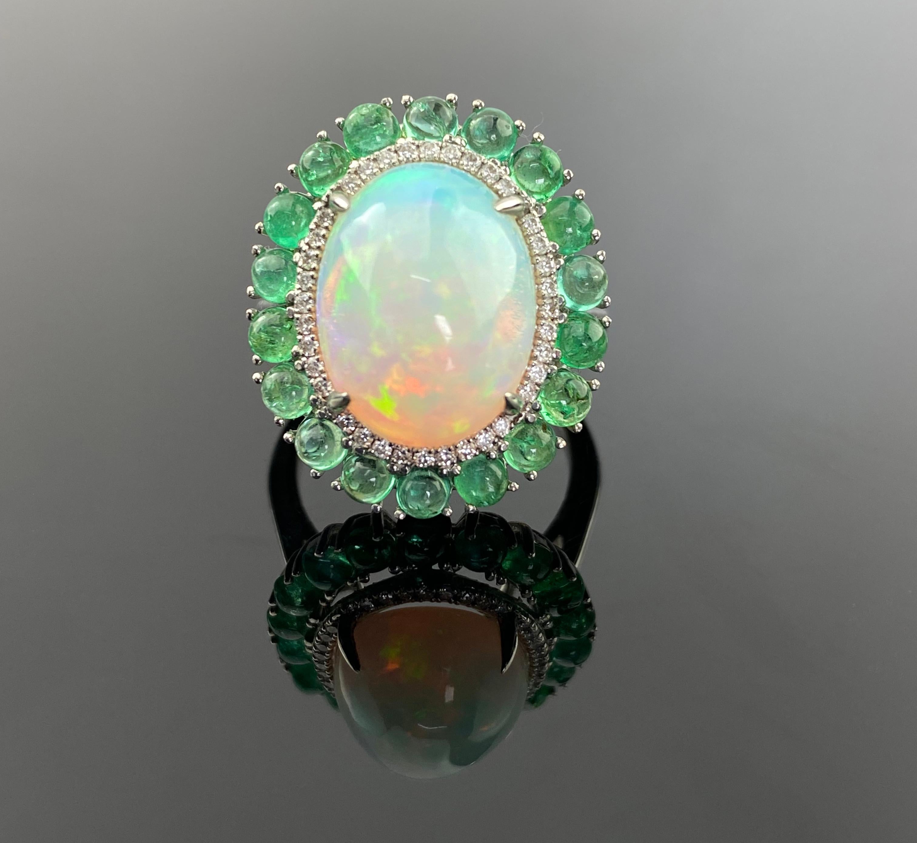 Eine schöne Kombination aus 5,64 Karat ovalem äthiopischem Opal-Cabochon und 2,59 Karat Smaragd-Cabochon, gefasst in massivem 18K Weißgold, mit 0,23 Karat Diamanten. 
Der Ring ist derzeit in der Größe US7, kann aber in der Größe geändert werden.