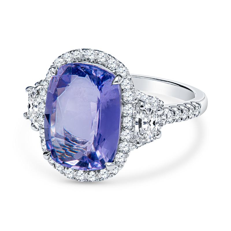 This beautiful cocktail ring features a 5.68 cushion cut natural violet sapphire accented by 0.55 carat total weight in round diamonds and 0.34 carat total weight in two step cut trapezoid diamonds. The cocktail ring is set in platinum and is