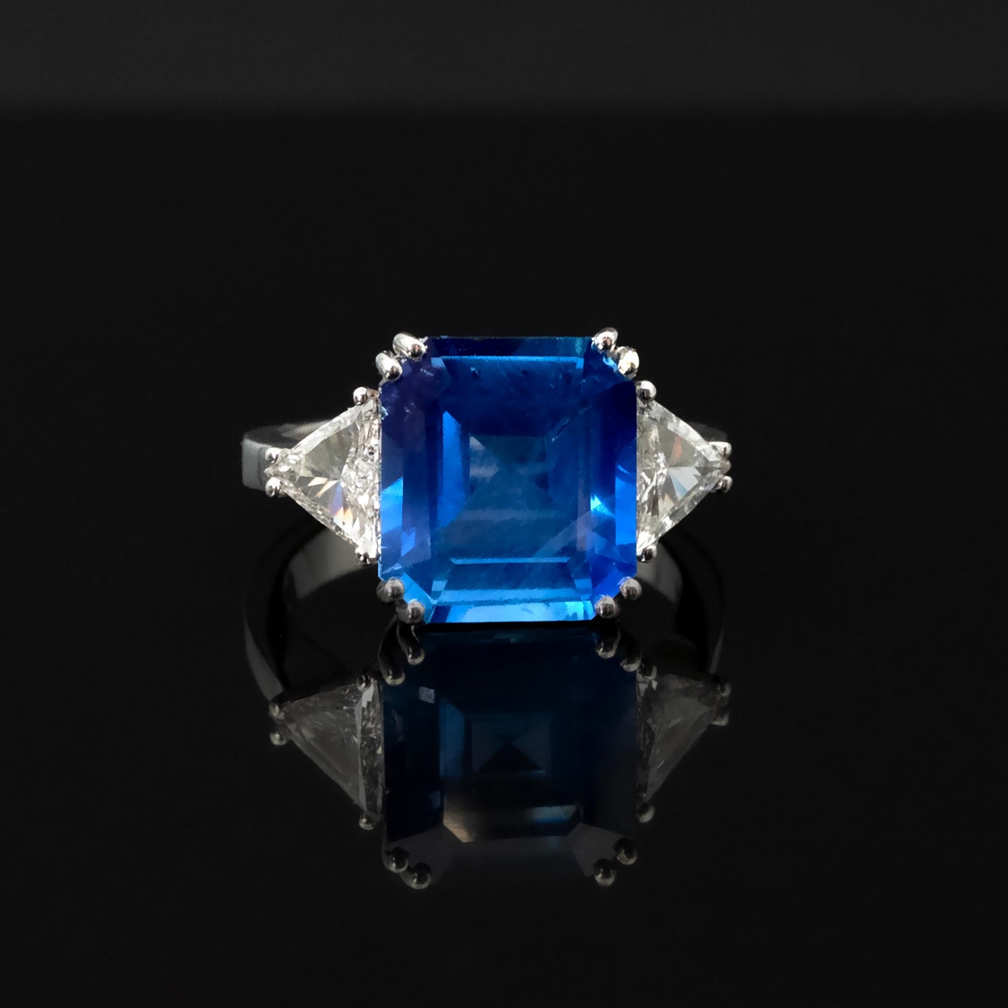 This exquisite engagement ring features a 5.77 carat Natural Sri Lankan (Ceylan) sapphire , brimming with life, with no Heat enhancement — a rarity in fine gemology. The gemstone's exceptional layout and octagonal emerald cut amplify its natural