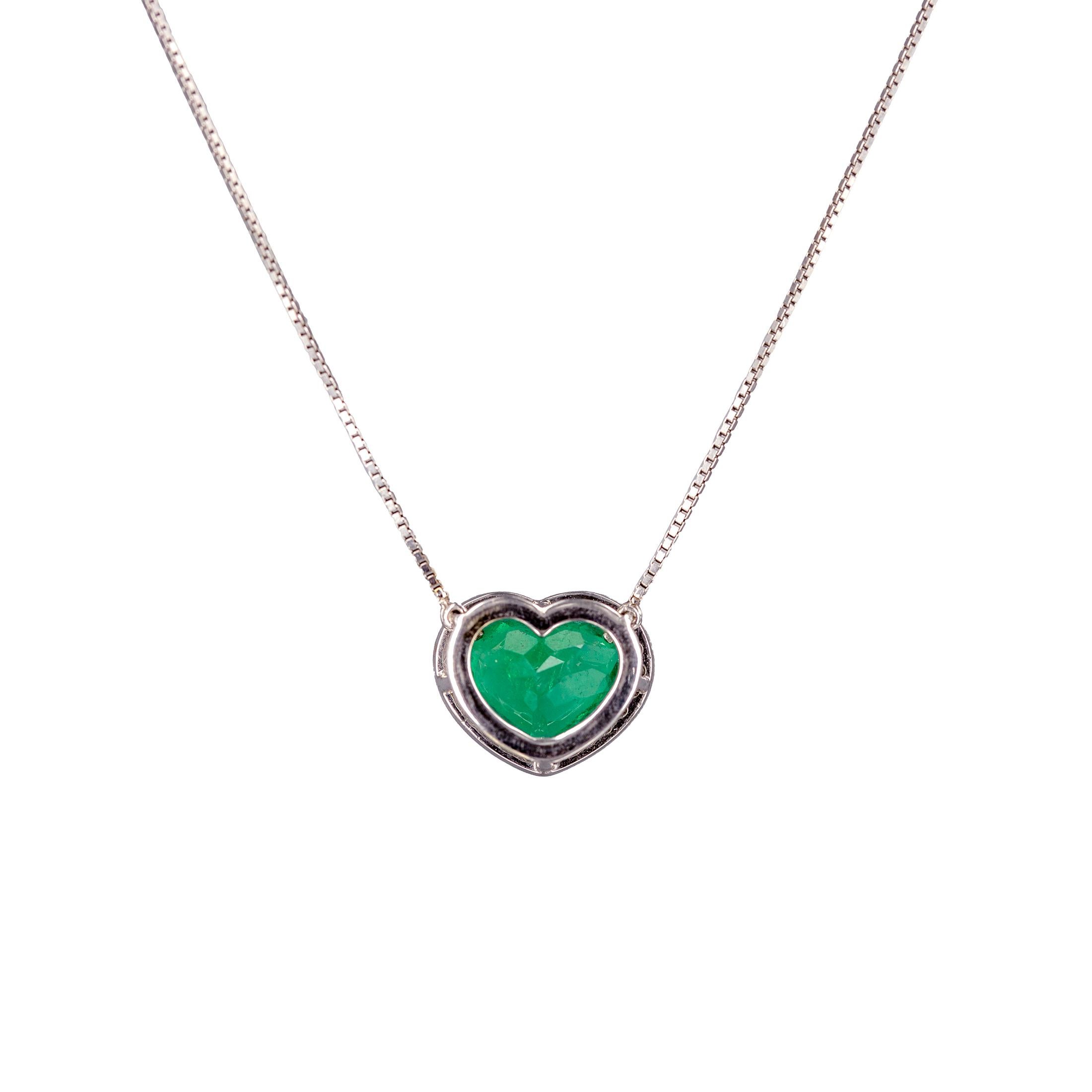 18 karat white and yellow gold pendant set 
with 5.98 carat heart shaped vivid green natural emerald from Muzo, Colombia and
25 diamonds of total weight 0.42 carat. The chain is attached, has 2 extension jump rings and fitted with a lobster clasp.