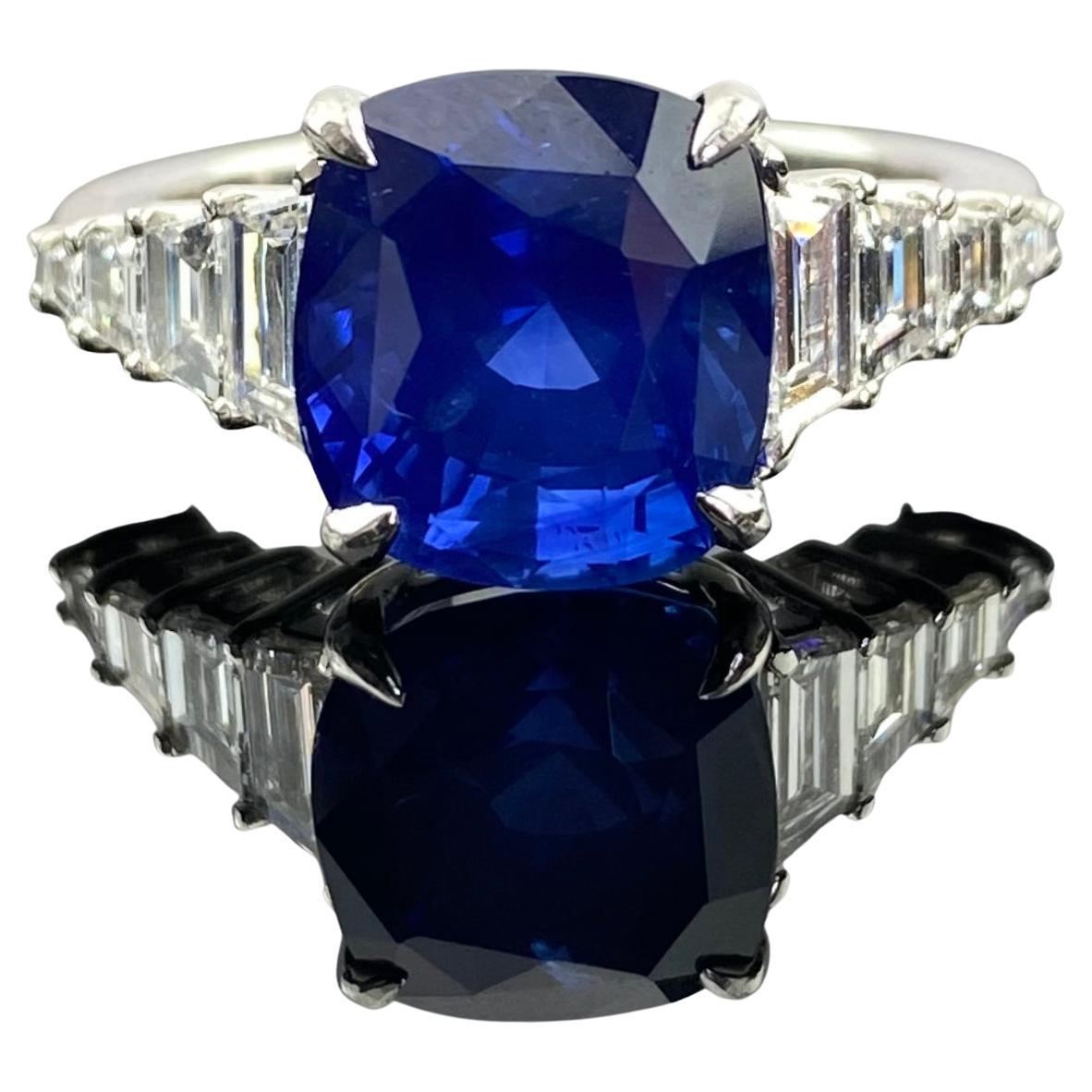 Indulge in the allure of this 18K white gold ring, adorned with a cluster of eight brilliant VVS quality diamonds totaling 0.88 carats and a mesmerizing Blue Sapphire weighing 6.05 carats. The diamonds shimmer with unmatched brilliance, perfectly