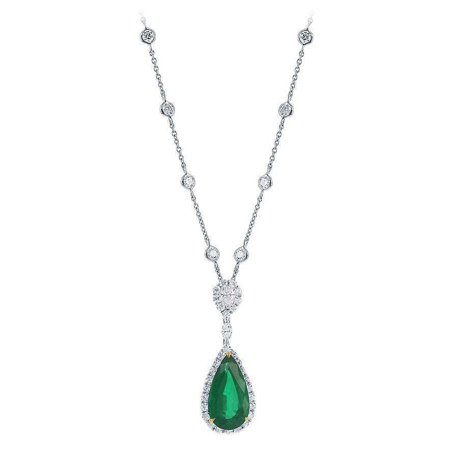A classic certified pendant necklace showcasing a pear-shaped emerald weighing 6.40 carats total. Embellished by a row of round diamonds, weighing 4.04 carats total. Suspended on a pear shape diamond halo surmount attached to a diamond by the yard