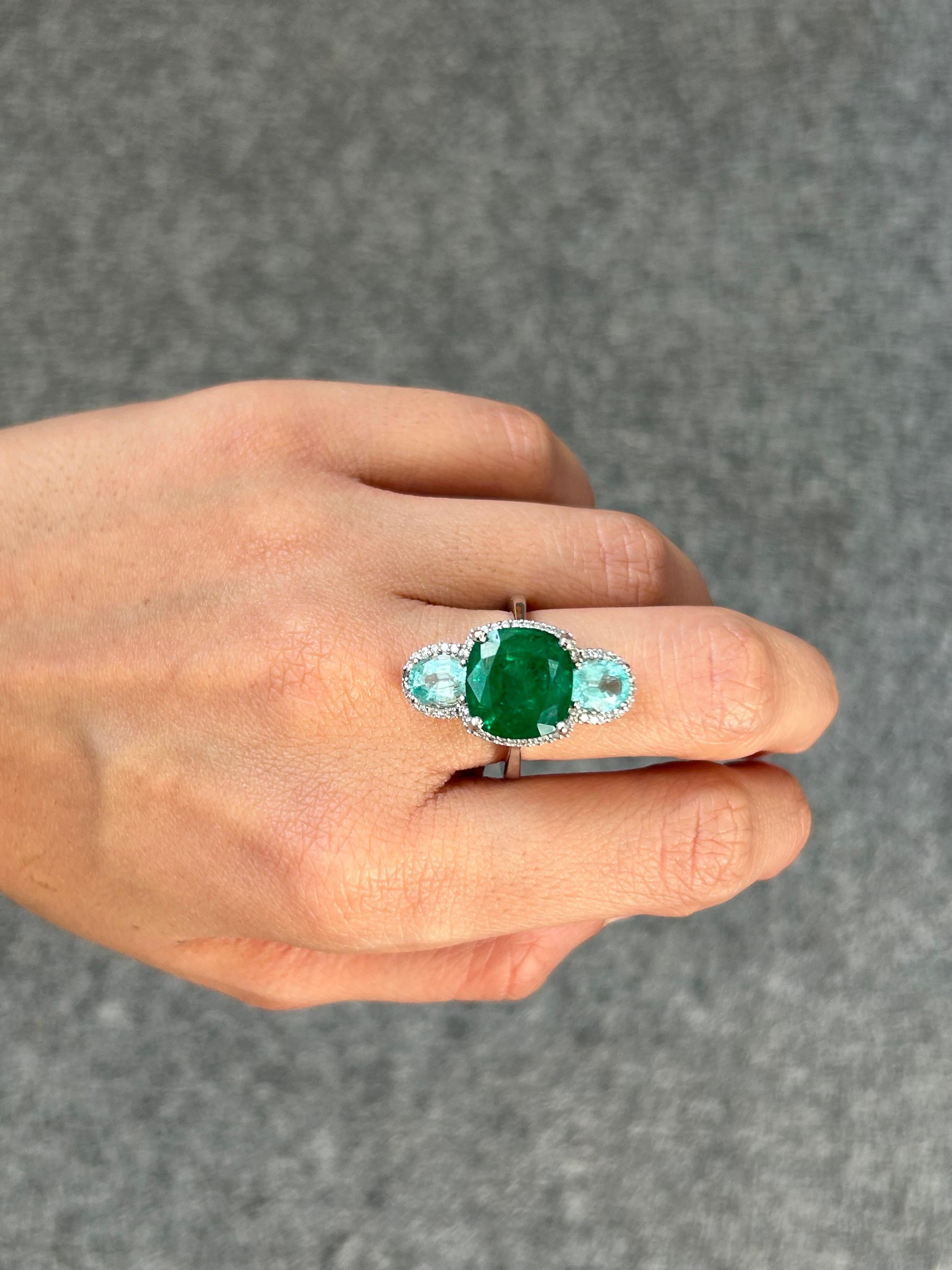 This custom-made 18k gold cocktail cluster ring features an exceptional display of craftsmanship and imaginative design, perfect for those who love the incredible color combination of high-quality green Emerald and aqua blue Paraiba. A cushion