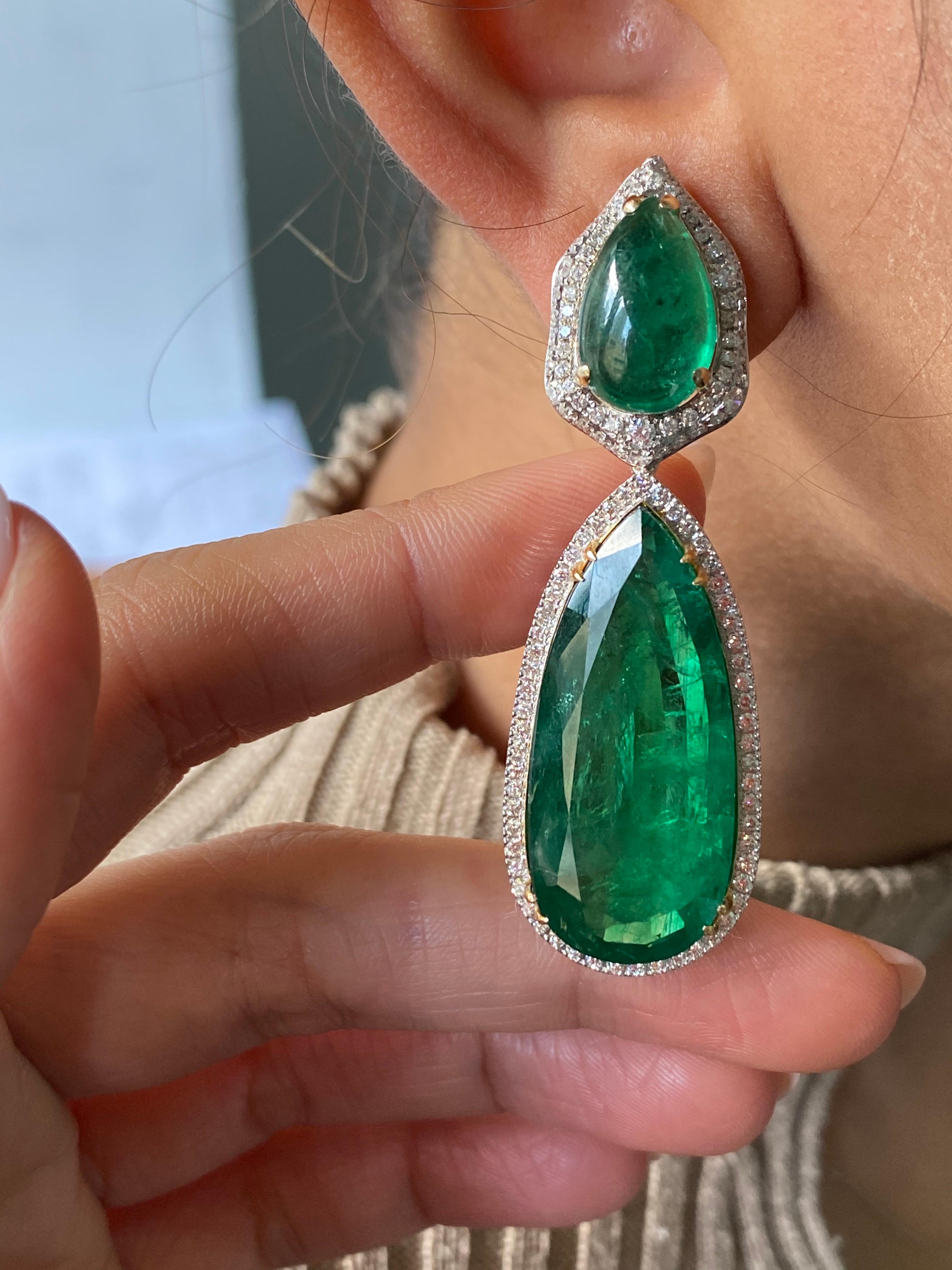 A pair of gorgeous 65.32 carats Zambian Emeralds and Diamond drop, dangle earrings, set in solid 18K White Gold. The top pear shape cabochon Emeralds weigh 10.88 carats in total, set with 2.91 carats of colorless VS quality White Diamonds. The