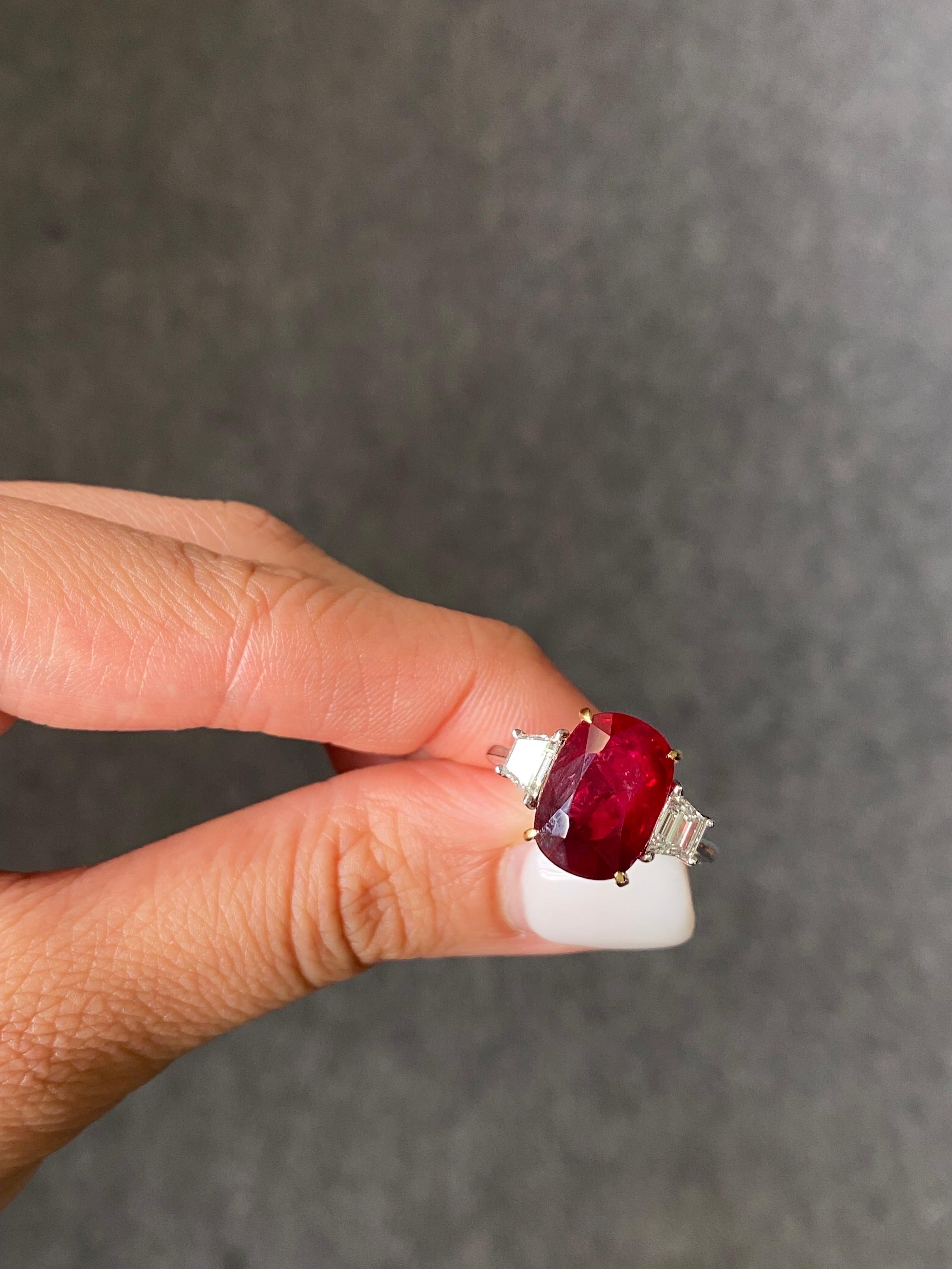 A classic 7.04 carat natural Ruby from Madagascar and 0.61 carat VS White Diamond three-stone engagement ring, set in solid 18K White Gold. The Ruby is transparent with a beautiful, vivid red, pigeon blood (as stated in the certificate). The ring is