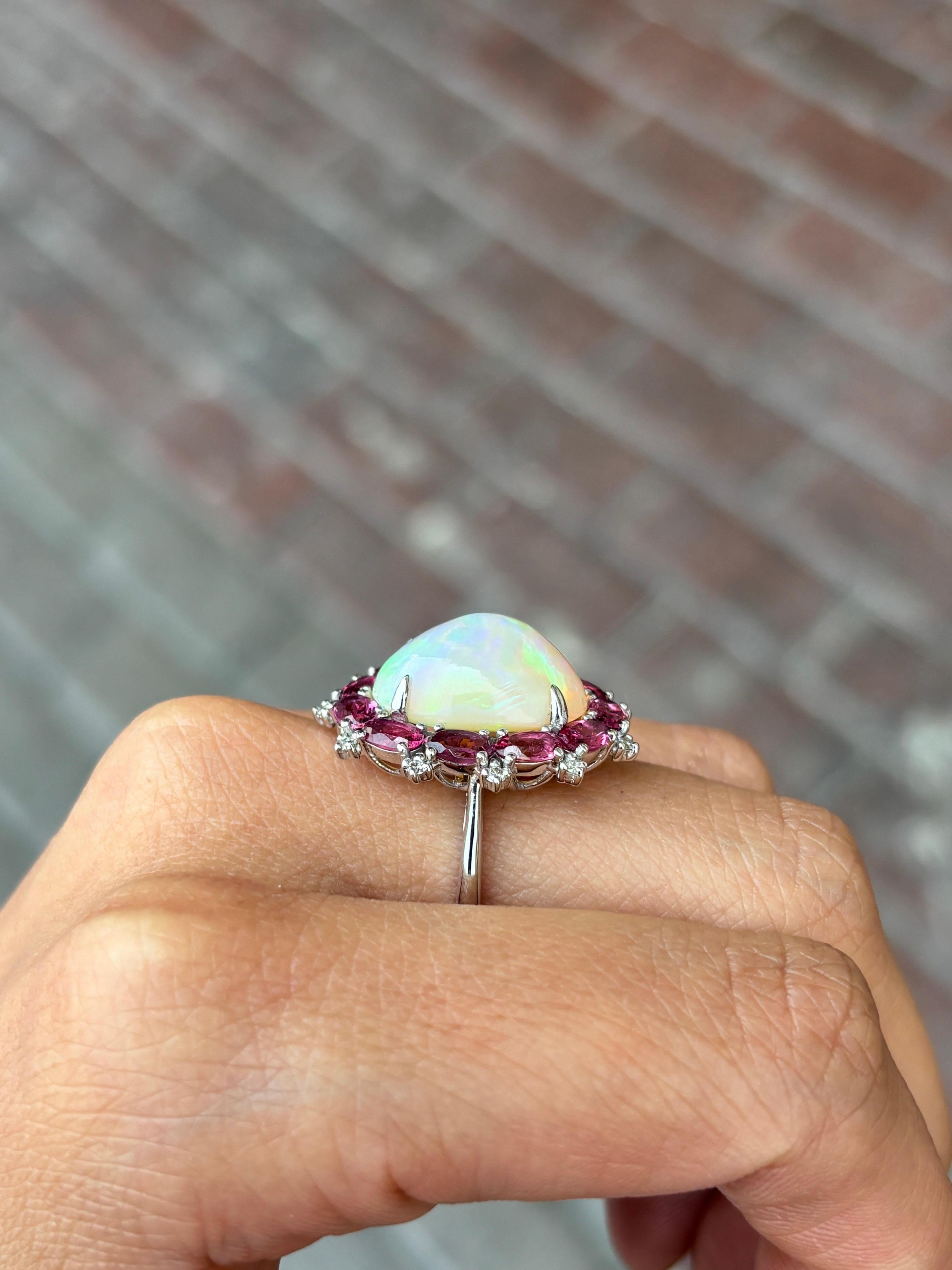 A beautiful combination of 7.10 carat oval shaped Ethiopian Opal and 2.40 carat oval shaped Rubellite set in solid 18K White Gold, with 0.14 carat of Diamonds. 
The ring is currently sized at US7, can be resized. 
Certificate available for the
