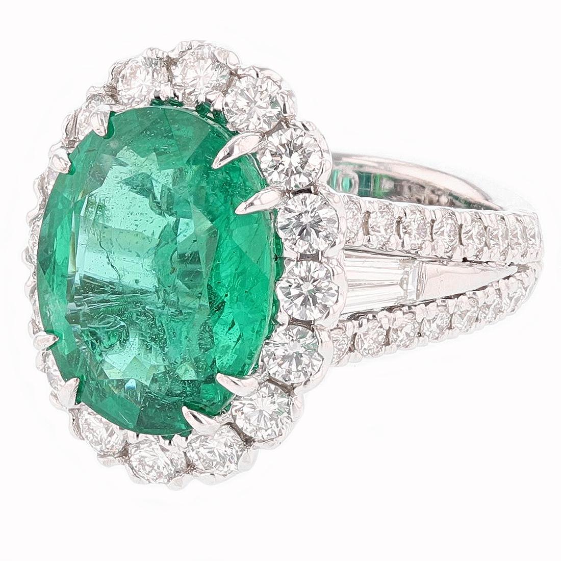 This ring is made in 14K white gold and features a 7.60ct Oval Cut Emerald center stone. The stone has a C.Dunaigre certificate with # CDC 1801820. The mounting features 50 round cut diamonds prong set weighing 2.07ct Color Grade (G) Clarity Grade