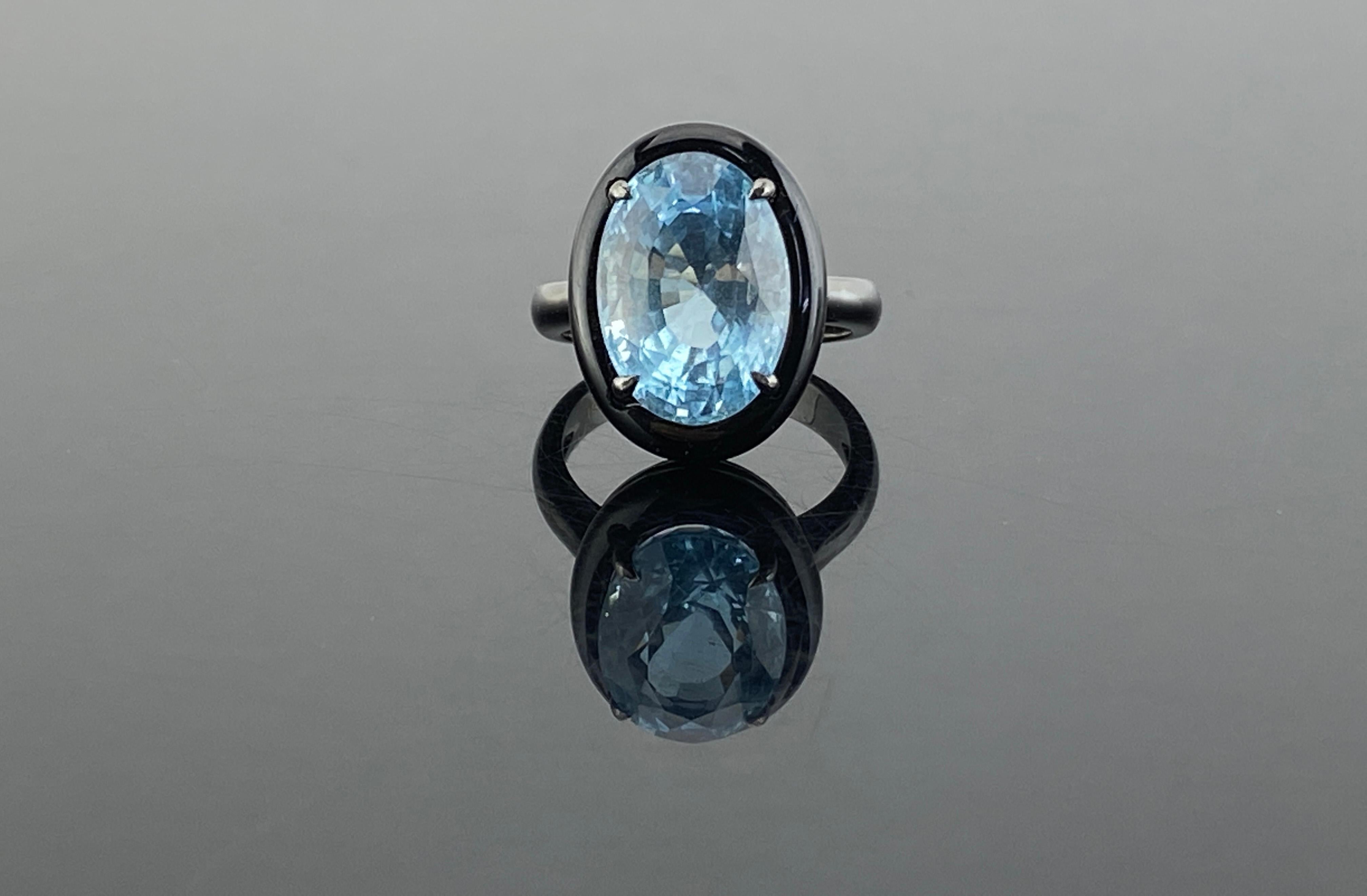 A stylish and classy ring, featuring a 7.76 carat aquamarine with a lovely sea-blue color. It is complemented by a piece of hand carved black onyx around it to give it a contrasting look  . Hand-fabricated in 18K gold and polished in black rodium .