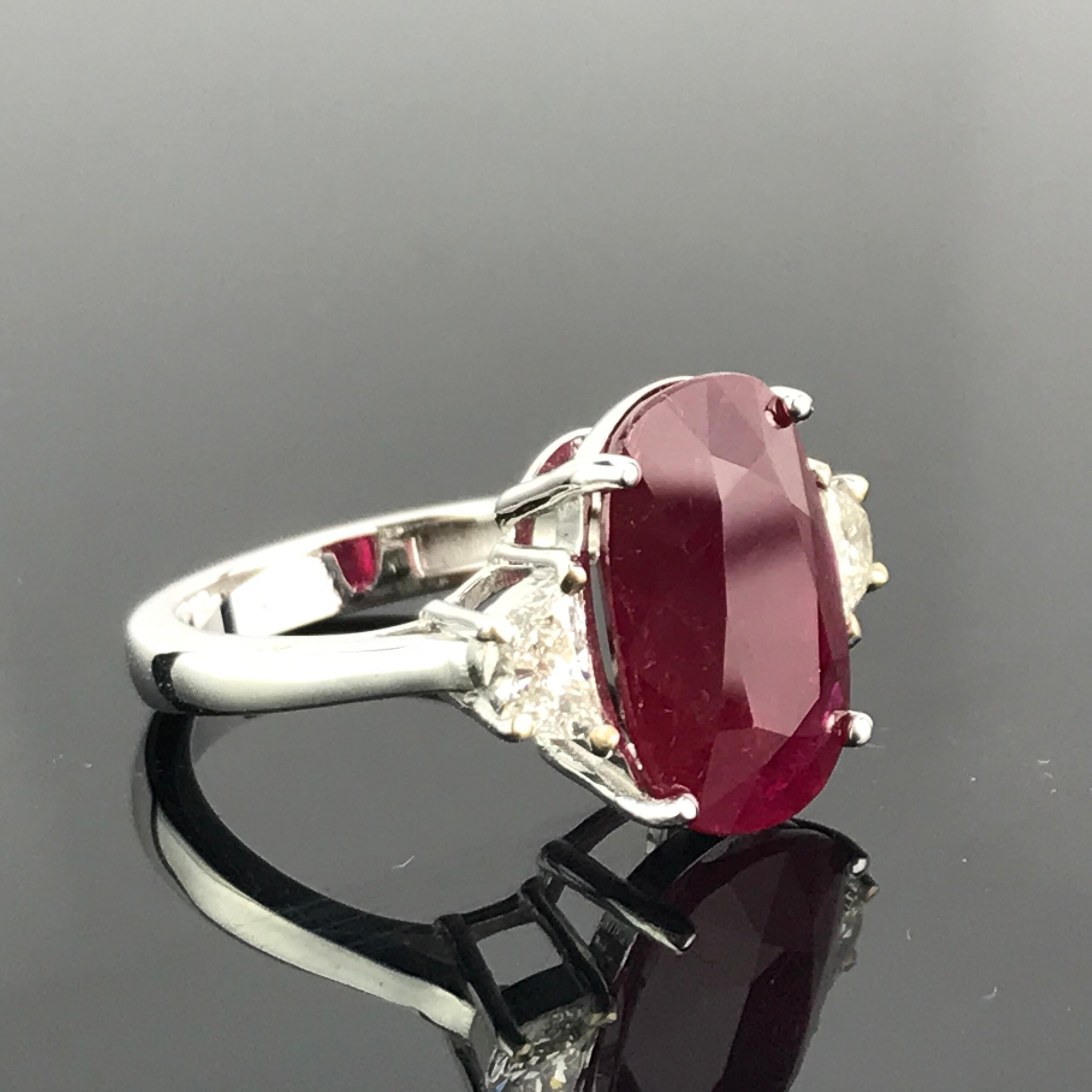 A gorgeous 7.85 carat, oval shaped, Burmese Ruby ring with 2 half-moon 0.74 carat White Diamonds, all set in 18K White Gold. Currently a ring size US 6, but we can resize the ring without additional cost. Link to a video of the ring can be